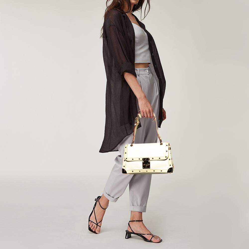 This Le Talentueux bag from Louis Vuitton is gorgeous. The white beauty is crafted from Suhail leather and flaunts a unique and distinctive style. It features beautiful gold-tone pyramid studs, a push-lock closure, and metal reinforced edges, all of