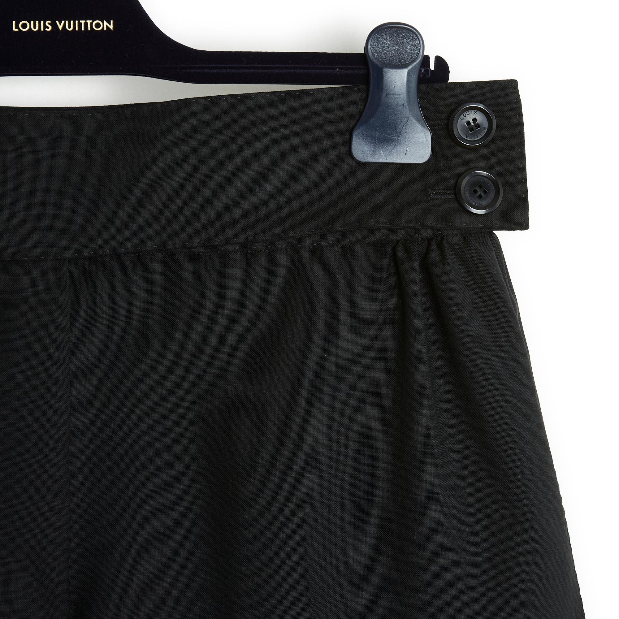 Louis Vuitton pants in black wool twill, extra large volume, high waist with crossed belt and 2 small gathers on each side, 2 slanted slit pockets in front, 2 horizontal slit pockets (always closed) in the back, wide cuff at the bottom of the leg,