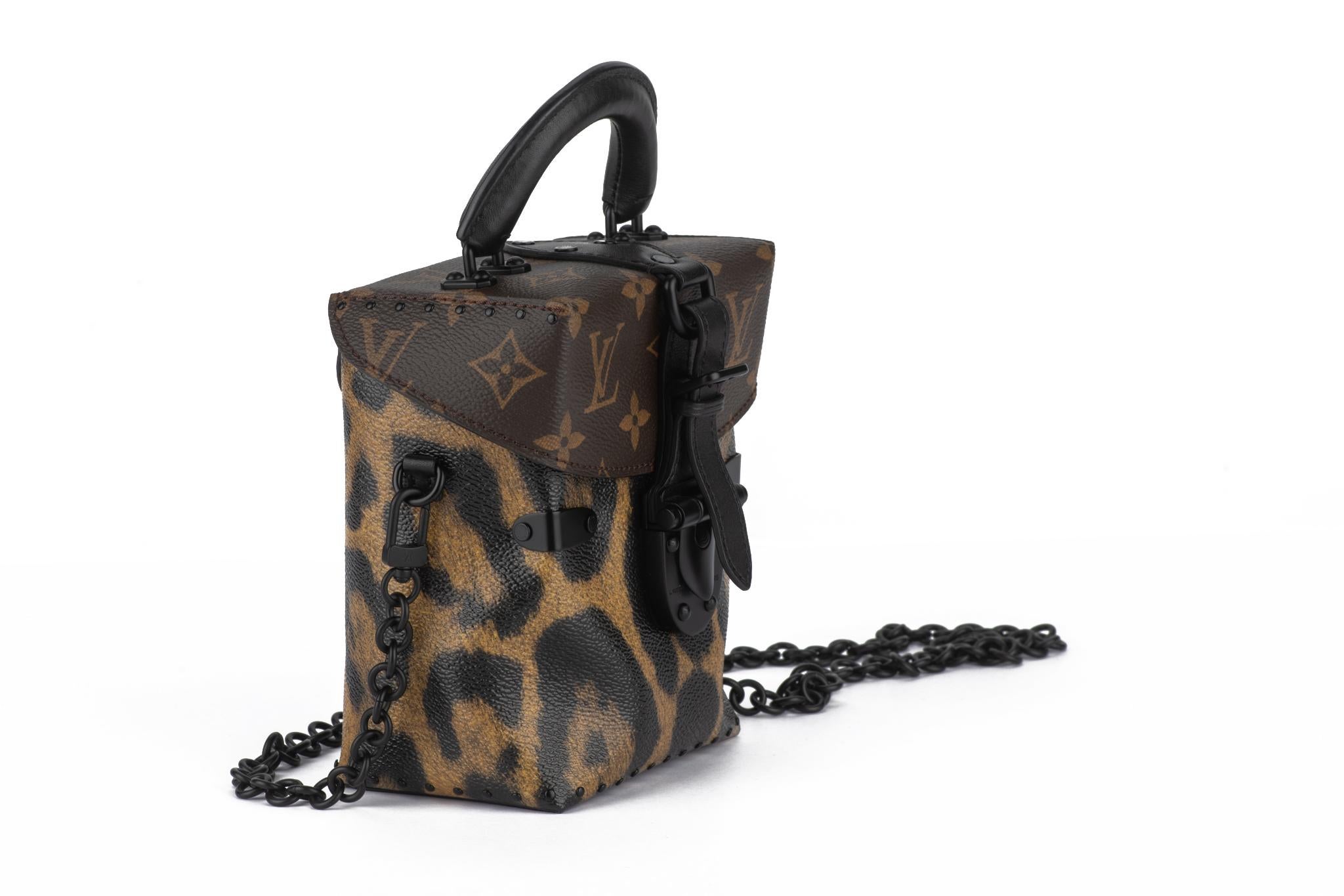 The Louis Vuitton Monogram and Wild Animal Print Camera Box is made of a coated canvas and black leather trim/metallic hardware. It features a black Toron handle and removable adjustable shoulder/crossbody strap. The interior has one slip