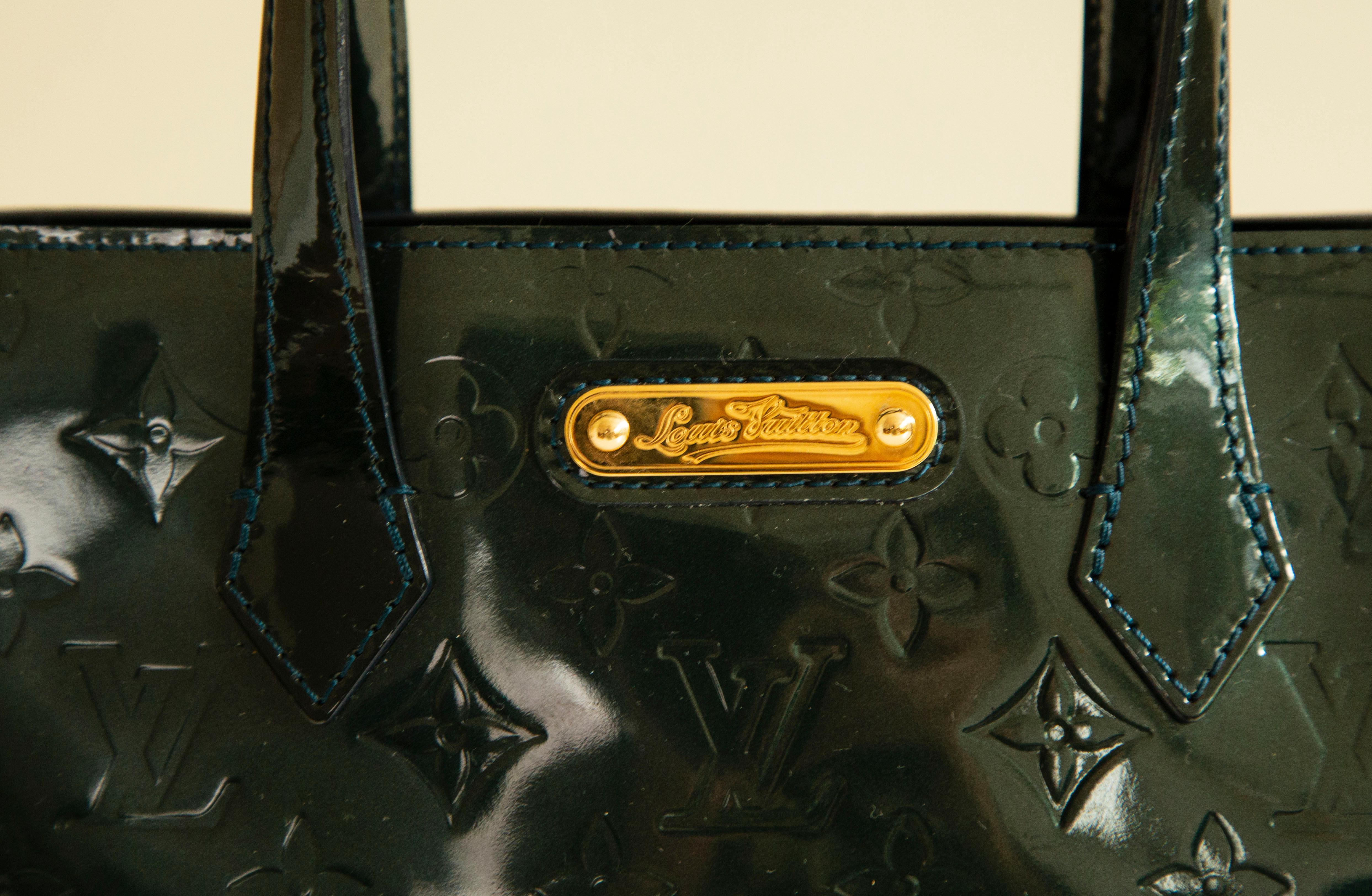 Sac fourre-tout Louis Vuitton Wilshire PM réalisé en cuir Monogram Vernis Bleu Nuit (couleur vert/bleu foncé) et conçu pour Louis Vuitton par Marc Jacobs en 1998. L'intérieur est doublé d'un tissu et, à côté du compartiment principal, il comporte