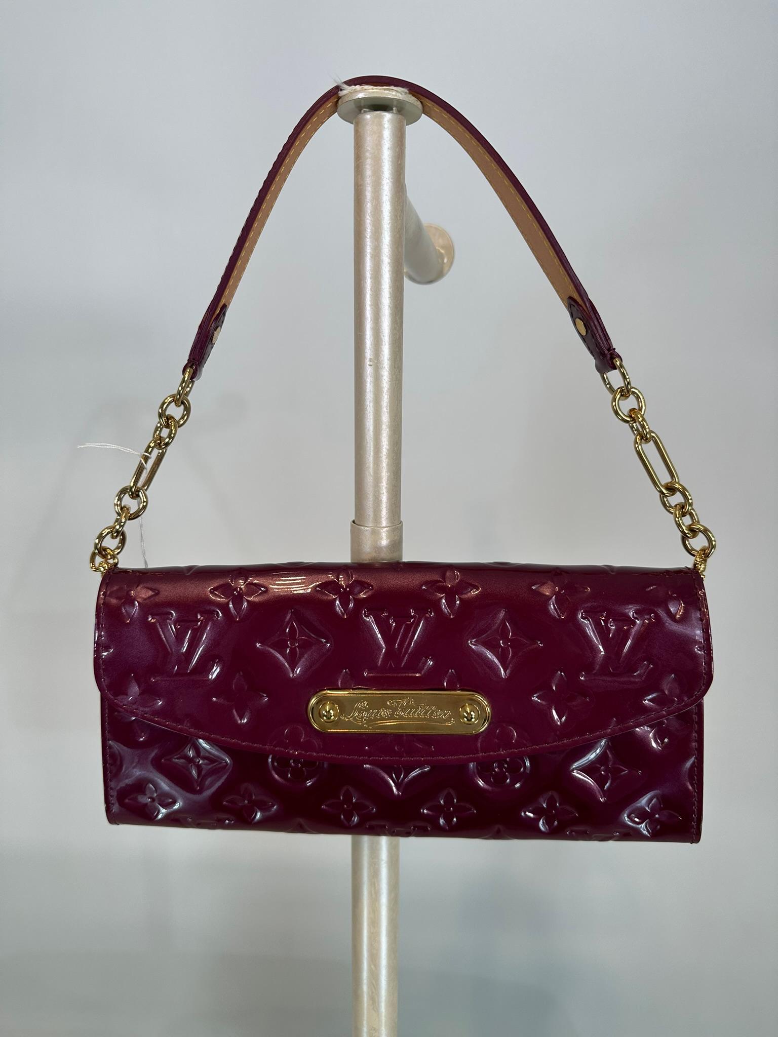 100% authentic Louis Vuitton 'Vernis Sunset Boulevard' WOC in monogram wine patent leather. Gold-tone hardware, logo plaque, flap front bag with a magnetic button closure. Lined in wine canvas with six interior leather card slots and a internal