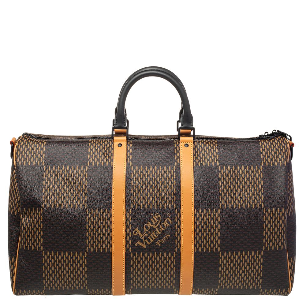 This updated version of the iconic LV Keepall is from Virgil Abloh's collaboration with Japanese designer Nigo for House Louis Vuitton. The bag, constructed using Giant Damier Ebene canvas, is complemented with leather trims, and the front is laid
