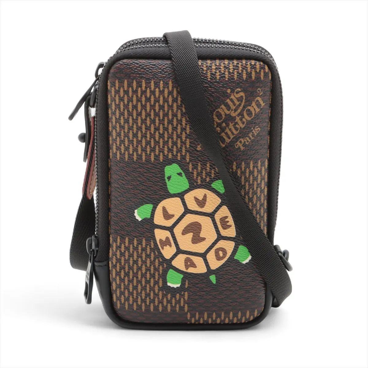 The Louis Vuitton x NIGO Damier Ebene Giant Double Phone Pouch is a unique and eye-catching piece that blends the maison’s heritage with the designer’s playful streetwear influence. Crafted from oversized Damier Ebene canvas, it is distinguished by