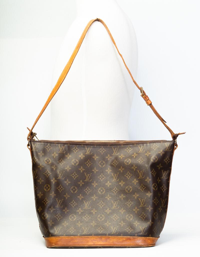 This rare & limited edition bag was designed and created by actress Sharon Stone in an effort to raise money for the AMFAR foundation which goes to AIDS research. Made of brown monogram coated canvas with tan vachetta leather finishes, brass