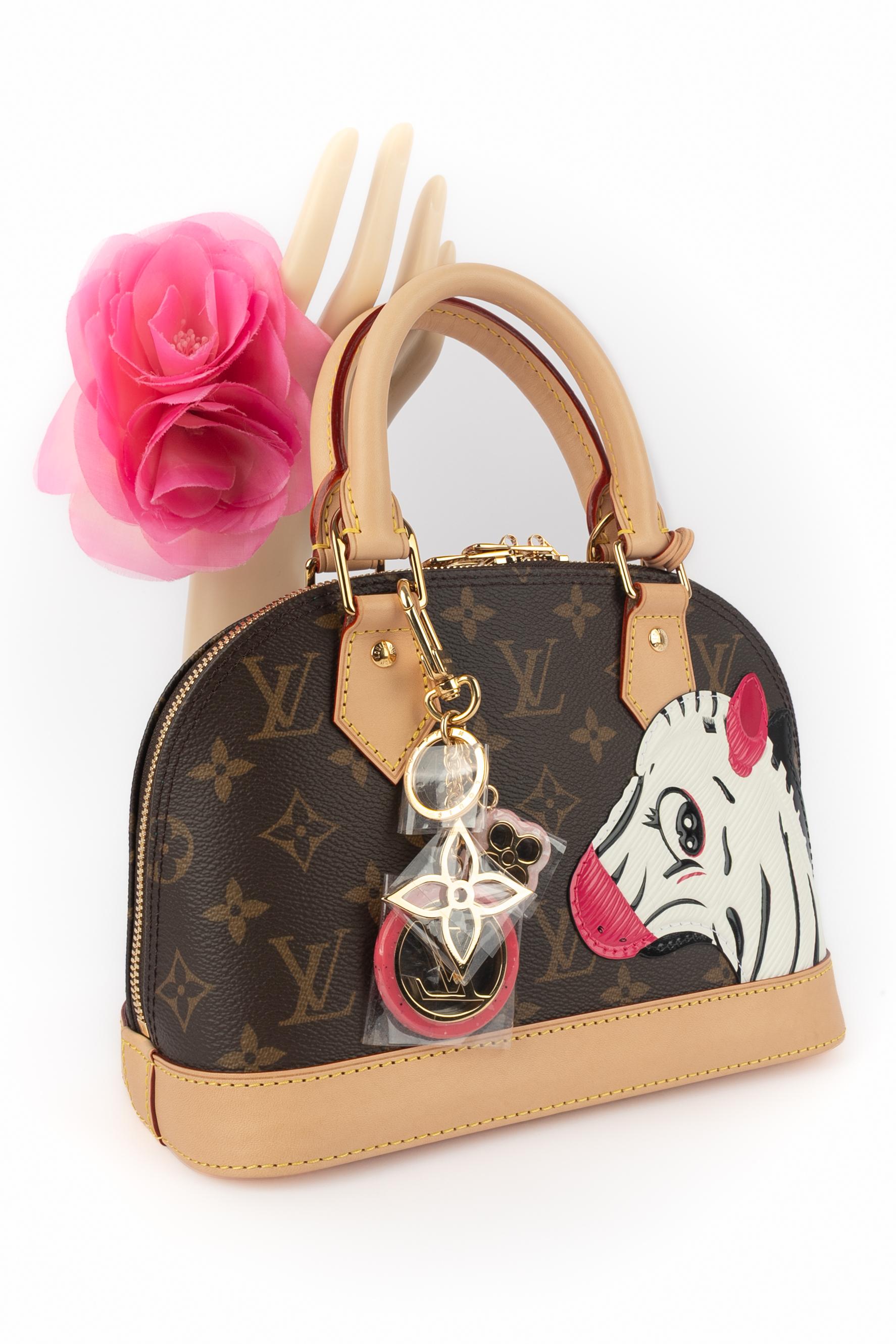 LOUIS VUITTON - (Fabriqué en France) Sac BB 'Alma' en cuir naturel et toile monogrammée orné d'un appliqué à motif zébré en cuir de cob. Poignée transversale amovible et bijoux de sac. Année 2024 Louis Vuitton X Sun Yitian Collectional.

Condit