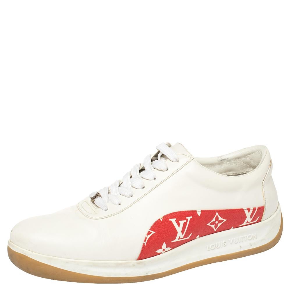 These Louis Vuitton x Supreme sneakers are fashioned in classic white leather with an appealing monogram canvas trim in a contrasting red hue accented on the quarters. They feature a lace-up silhouette with the brand logo and leather lining on the