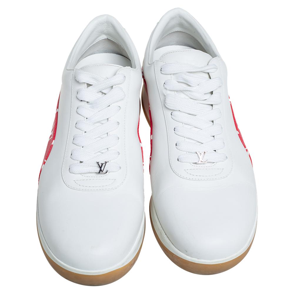 These Louis Vuitton x Supreme sneakers are fashioned in classic white leather with an appealing monogram canvas trim in a contrasting red hue accented on the quarters. They feature a lace-up silhouette with the brand logo and leather lining on the