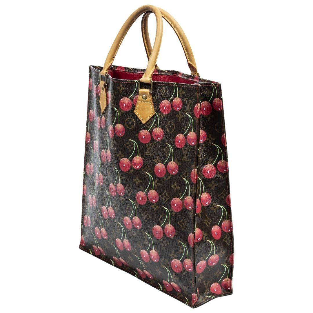 This is such a spirited and iconic Louis Vuitton piece! We live for the Takashi Murakami Collab of the 2000s. This one is crafted of the iconic cherries throughout over monogram coated canvas, dual rolled Vachetta handles and the open top opens up