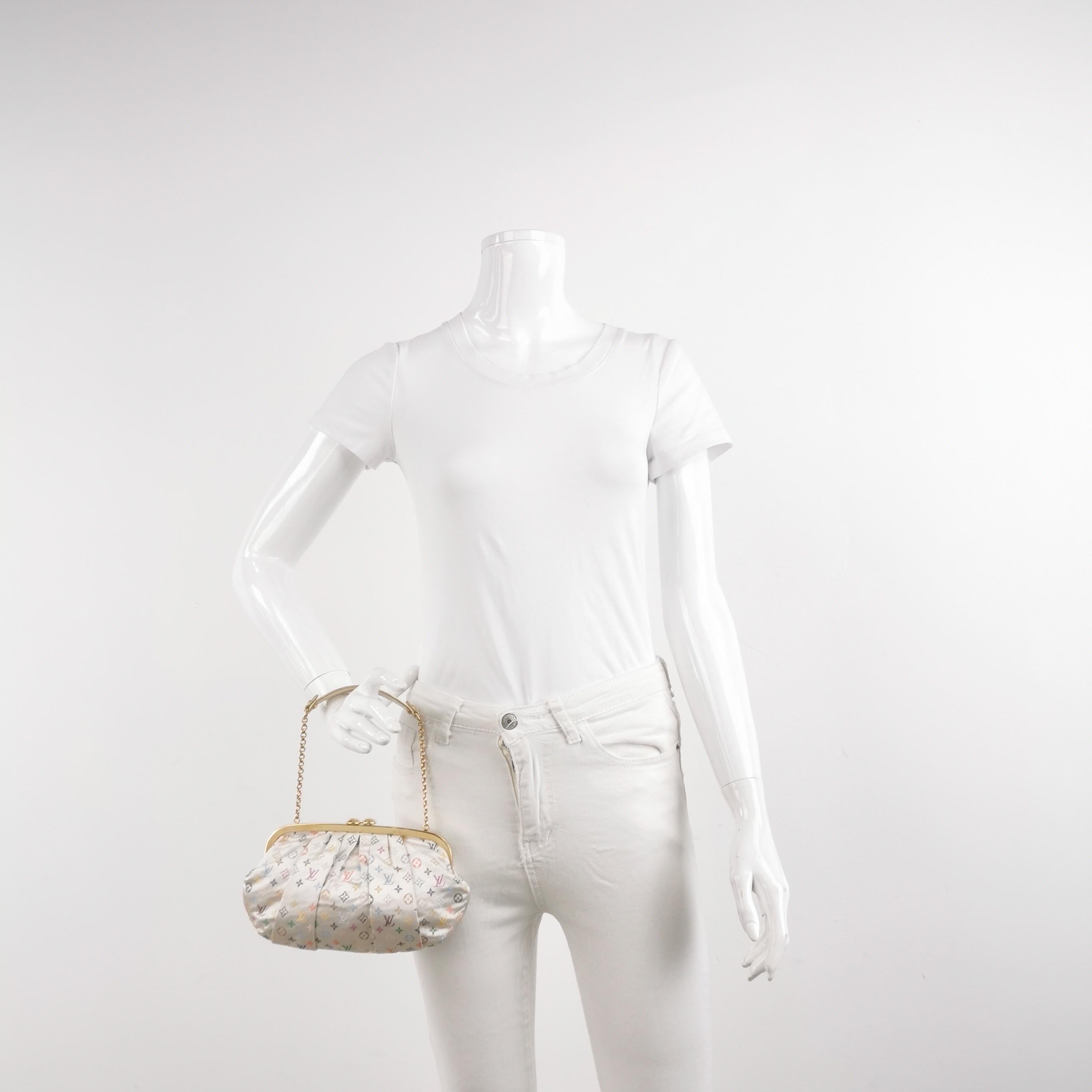 Presentamos el bolso de noche Aumoniere de satén con monograma blanco de Louis Vuitton x Takashi Murakami, un bello complemento para cualquier atuendo formal. Este bolso está adornado con una cadena dorada y  correa, marco superior dorado y detalles