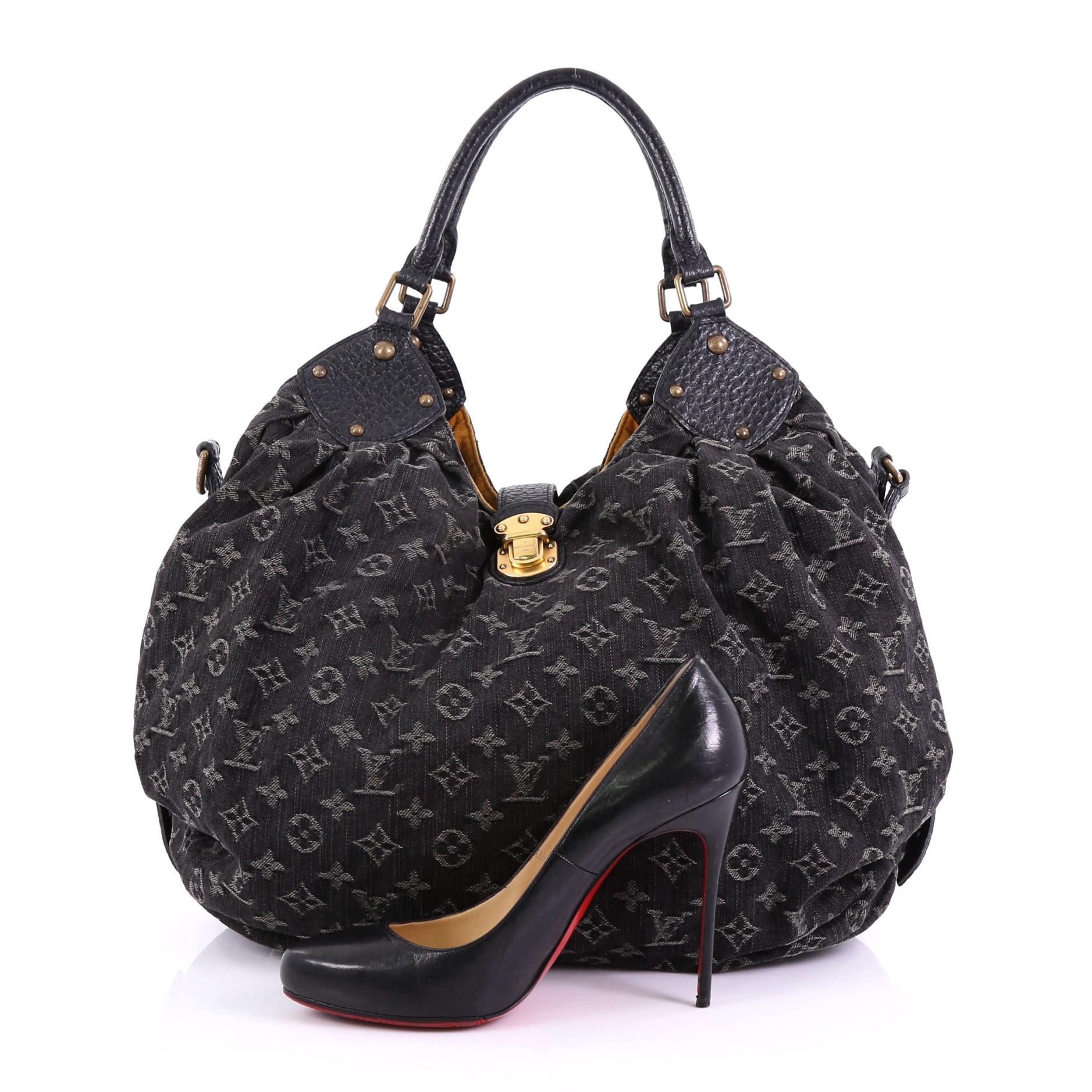 This Louis Vuitton XL Hobo Denim, crafted from black monogram denim, features dual rolled handles, protective base studs, belts on both sides, and aged gold-tone hardware. Its leather tab with push-lock closure opens to a yellow microfiber interior