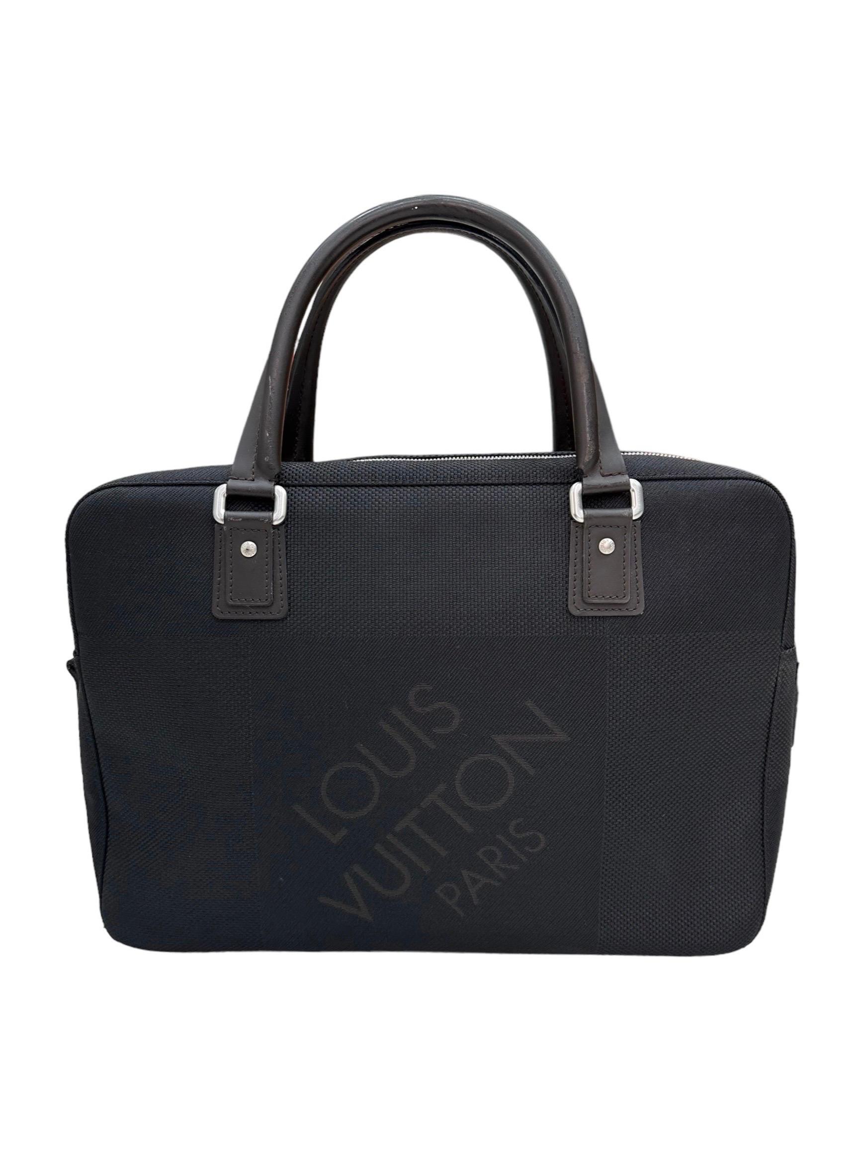 Louis Vuitton signed bag, Yack model, size GM, made in black canvas with brown leather inserts and golden hardware. Featuring a top zip closure. Equipped with two rigid handles made of smooth brown leather and a comfortable front pocket with zip