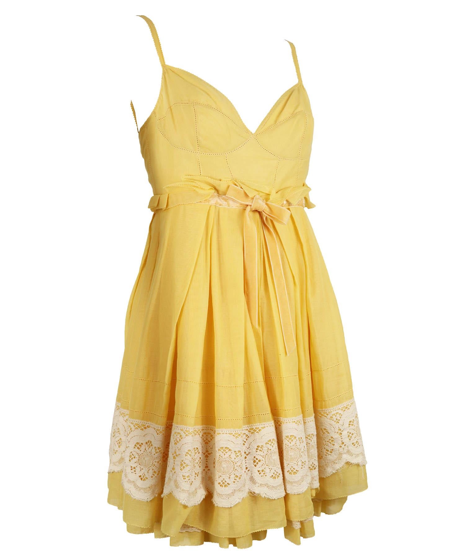 Louis Vuitton vintage babydoll sundress from the early 2000's in yellow cotton with white lace at the bottom hem and at bodice. Dress is featured in yellow lightweight cotton with a velvet ribbon empire waist, full skirt, mini above knee length,