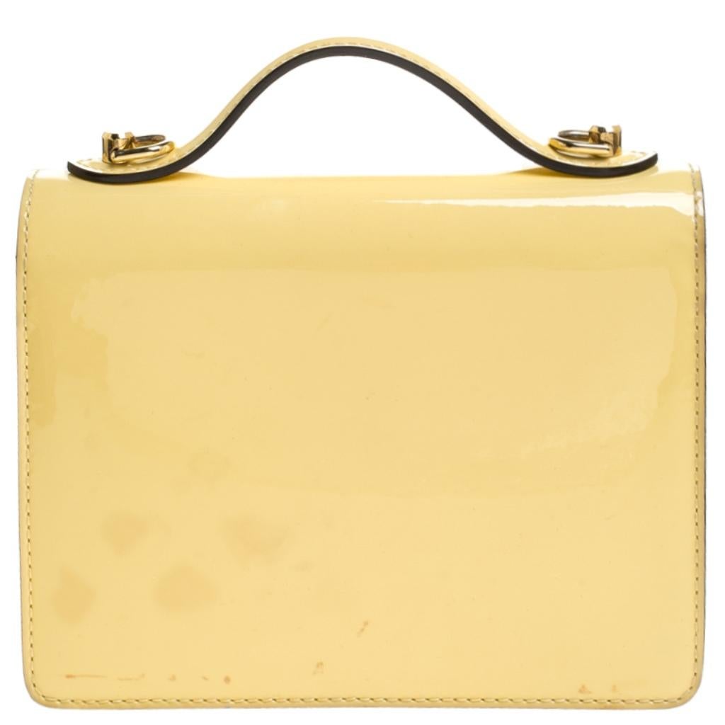 In a beautiful yellow color, this Louis Vuitton bag is pure perfection. It is designed with patent leather, gold-tone hardware and the signature S lock fastening carrying the brand engravings. Its top handle is coupled with a detachable shoulder