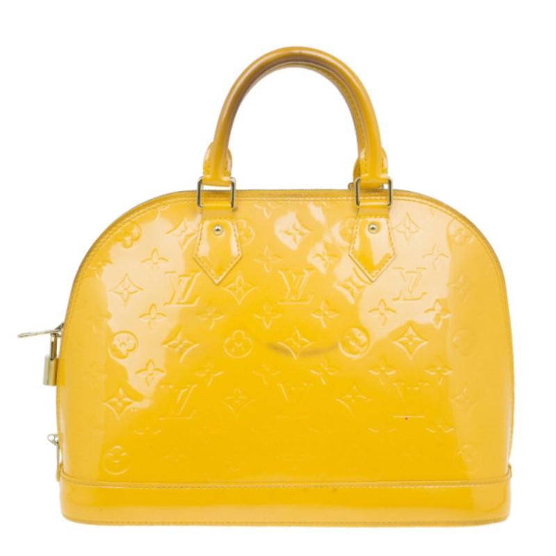 Created in the 1930′s by Gaston Vuitton, the well known and continually re-invented Alma is a classic. This version of the structured dome shaped handbag is crafted from bright yellow LV monogram Vernis leather. The exterior has a zip around