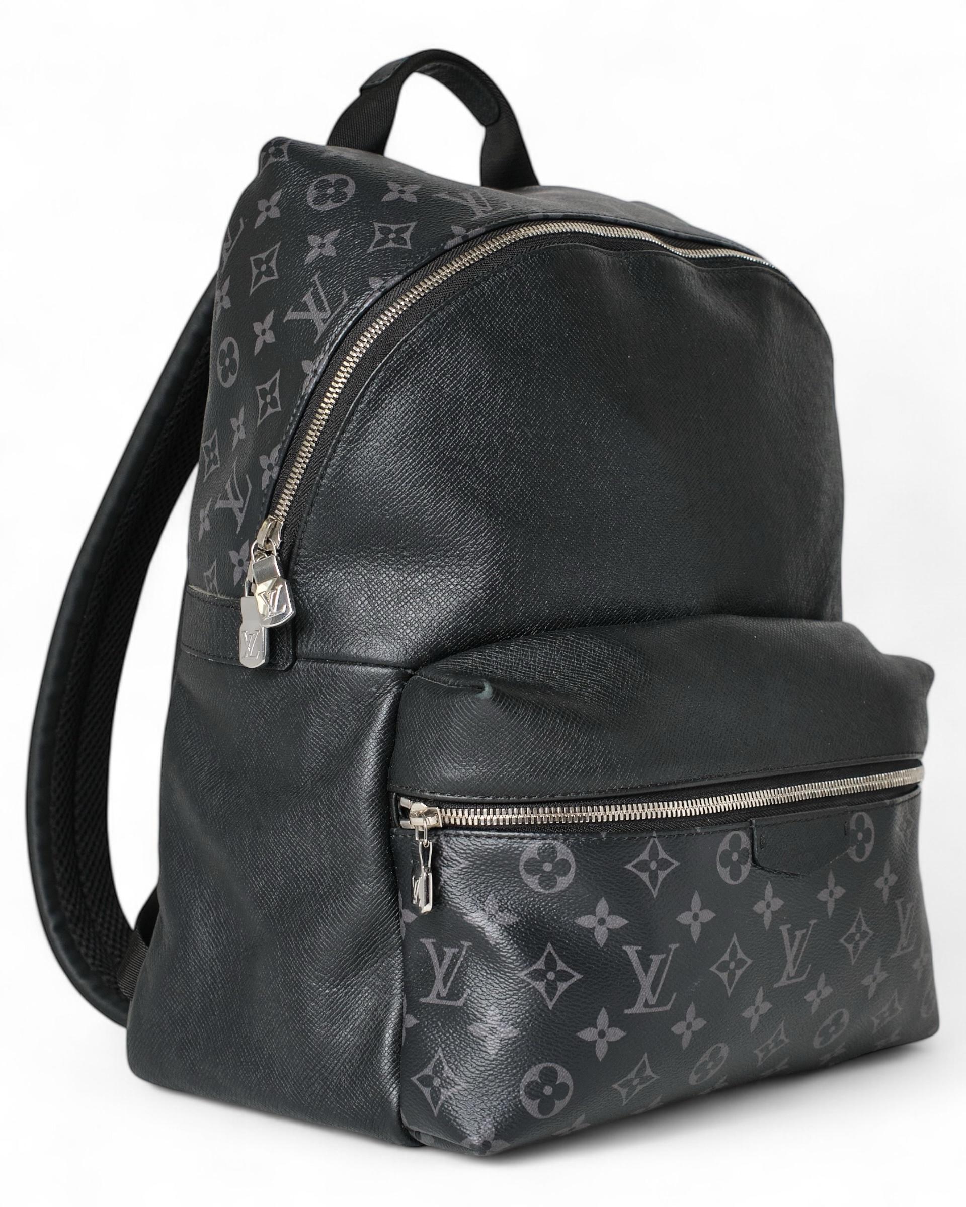 Sac à dos Louis Vuitton, modèle Discovery en taille GM, réalisé en toile avec le motif iconique Monogram Eclipse, finition en cuir et quincaillerie argentée. Doté d'une fermeture à glissière semi-circulaire à double curseur, l'intérieur est doublé