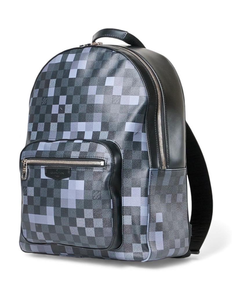 Zaino firmato Louis Vuitton, modello Josh, misura MM, realizzato in tela con la raffinata fantasia damier graphite pixel, arricchito da inserti in pelle nera e hardware argentati. Dotato di una chiusura semicircolare a zip con doppio cursore,