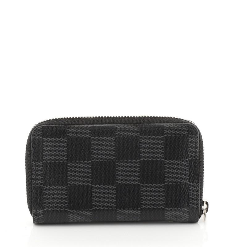 This Louis Vuitton Zippy Coin Purse Damier Graphite Vertical, crafted in damier graphite coated canvas, features silver-tone hardware. Its all-around zip closure opens to a black leather interior. Authenticity code reads: MI4167. 

Estimated Retail