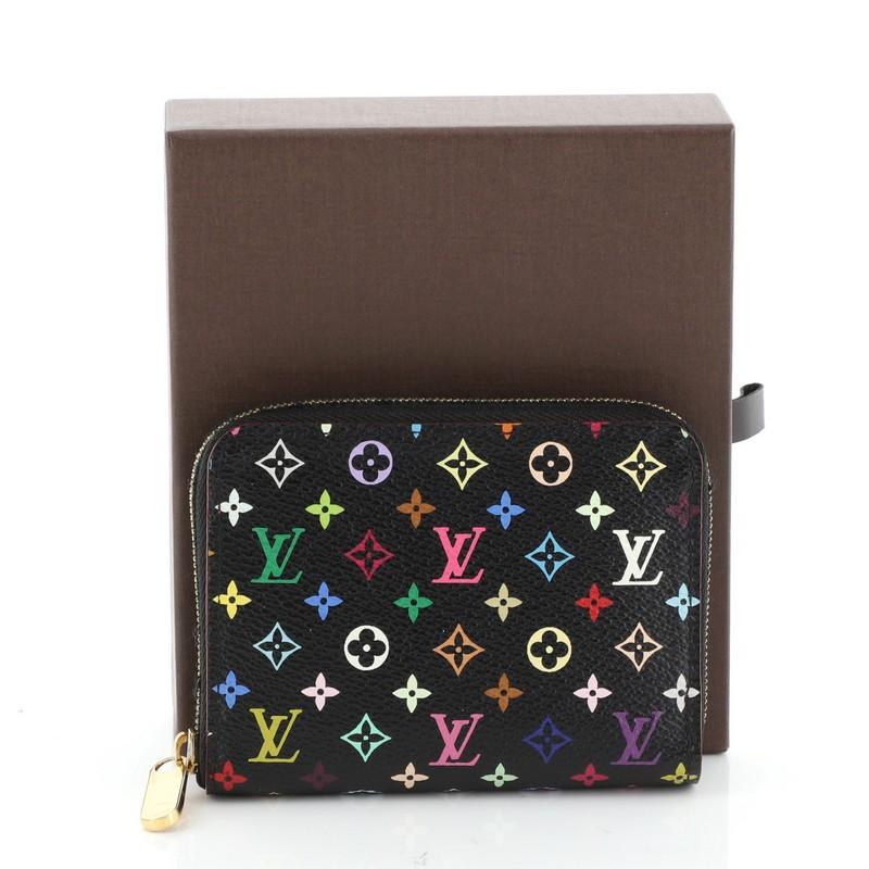 This Louis Vuitton Zippy Coin Purse Monogram Multicolor, crafted in black monogram multicolor coated canvas, features gold-tone hardware. Its all-around zip closure opens to a red leather interior with multiple card slots. Authenticity code reads: