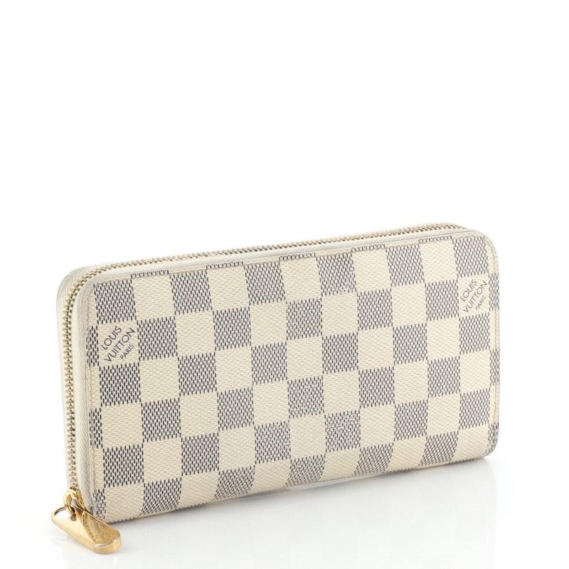 This Louis Vuitton Zippy Wallet Damier, crafted from damier azur coated canvas, features gold-tone hardware. Its all-around zip closure opens to a neutral leather interior with multiple card slots, two gusseted open pockets, and zip pocket.