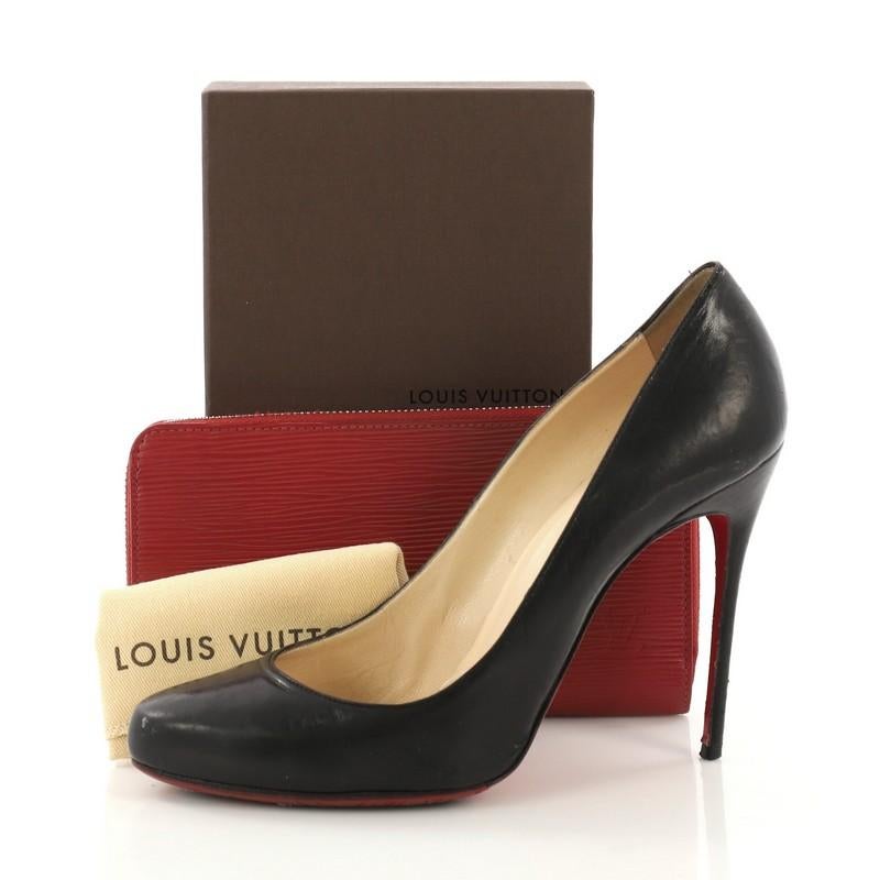 This Louis Vuitton Zippy Wallet Epi Leather, crafted in red epi leather, features silver-tone hardware. Its zip around closure opens to a red leather interior with multiple card slots, zip compartment, and slip pocket. Authenticity code reads: