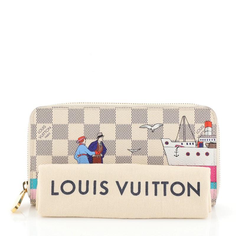 This Louis Vuitton Zippy Wallet Limited Edition Damier, crafted from damier azur canvas, features a printed vintage illustration and gold-tone hardware. Its zip closure opens to a pink leather interior with multiple card slots, gusseted open