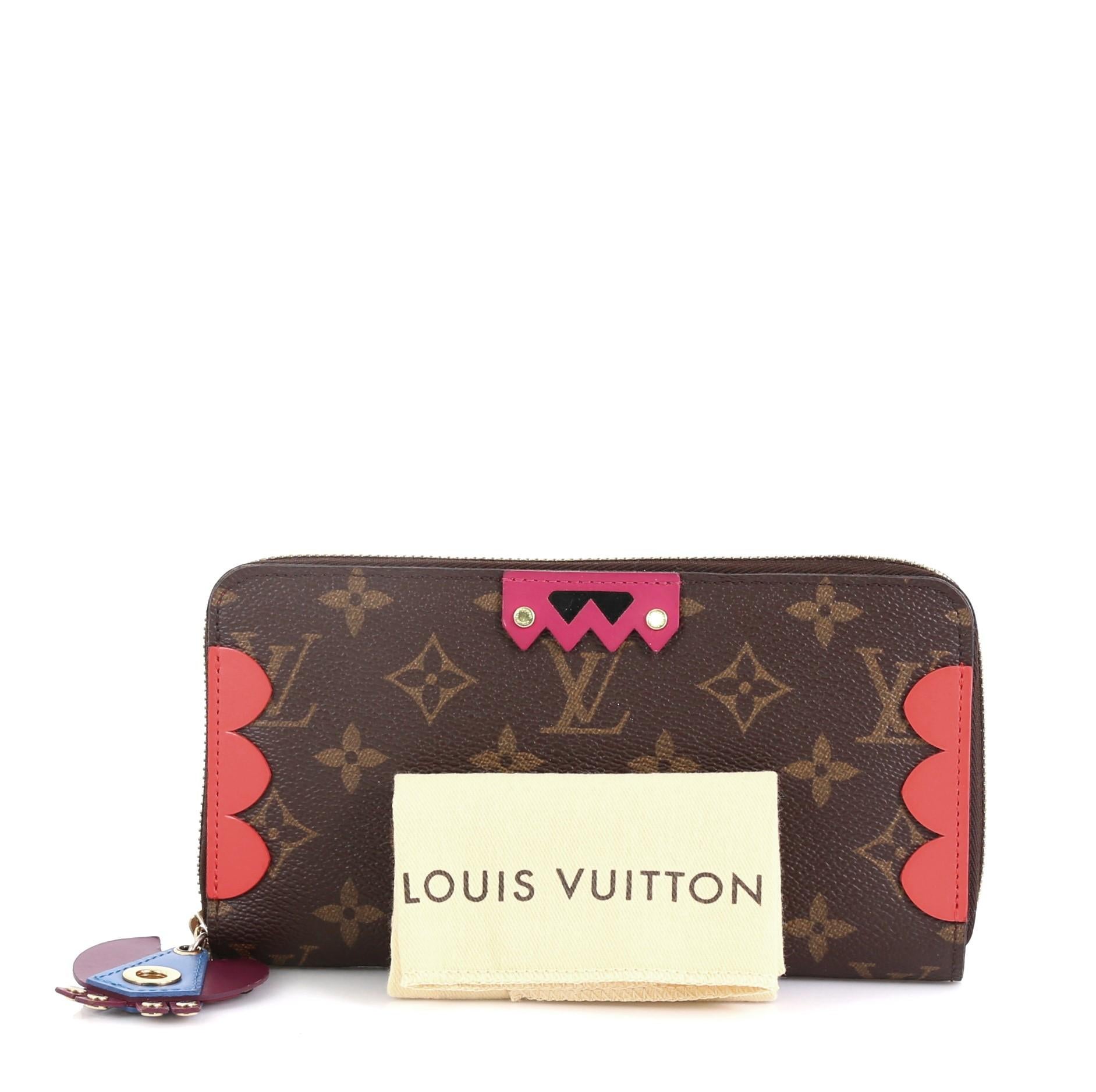 This Louis Vuitton Zippy Wallet Limited Edition Totem Monogram Canvas, crafted in brown monogram coated canvas, features tribal motif leather accents, multicolor tribal zipper pull and gold-tone hardware. Its zip closure opens to a red leather