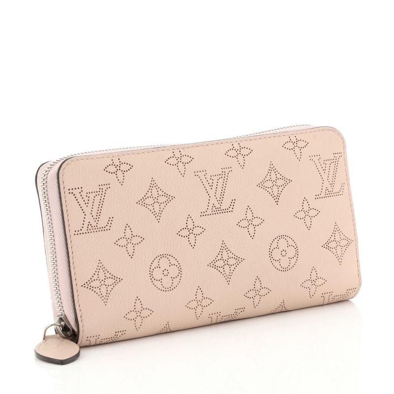 This Louis Vuitton Zippy Wallet Mahina Leather, crafted from pink monogram mahina leather, features silver-tone hardware. Its all-around zip closure opens to pink leather interior with multiple card slots, slip pocket and zip compartment.