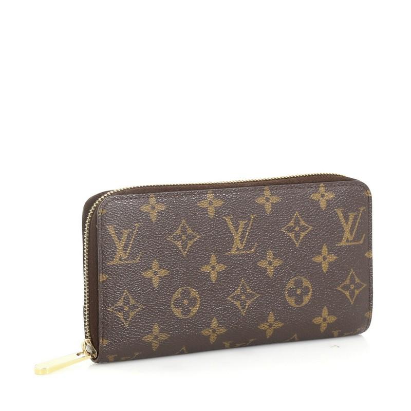 This Louis Vuitton Zippy Wallet Monogram Canvas, crafted from brown monogram coated canvas, features gold-tone hardware. Its all-around zip closure opens to a brown leather interior with multiple card slots, slip pocket, and zip compartment.