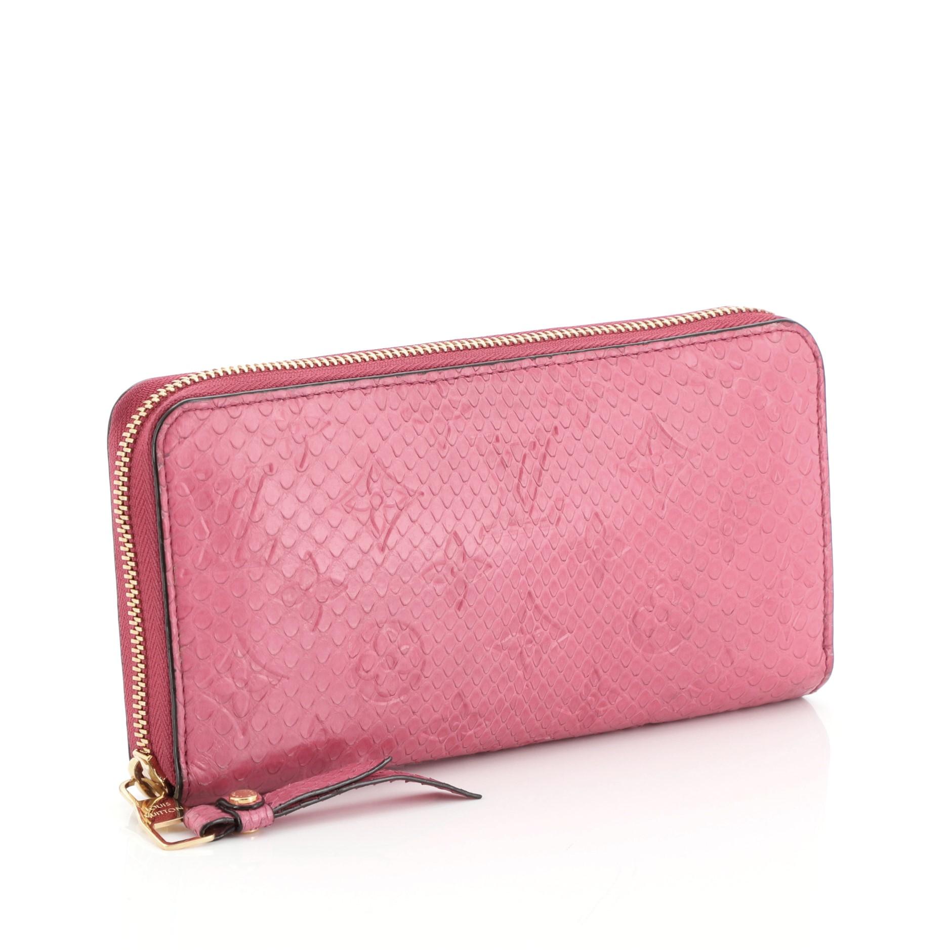 This Louis Vuitton Zippy Wallet Monogram Python, crafted from genuine pink monogram python, features gold-tone hardware. Its all-around zip closure opens to a pink leather interior with multiple card slots, slip pocket, and zip compartment.