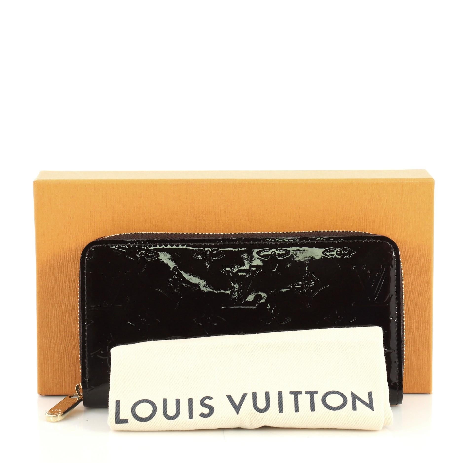 This Louis Vuitton Zippy Wallet Monogram Vernis, crafted in purple monogram vernis, features gold-tone hardware. Its all-around zip closure opens to a purple leather interior with a middle zip compartment, slip pocket, and multiple card slots.