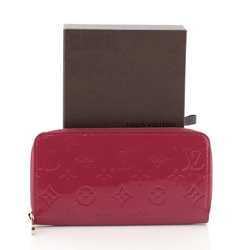 This Louis Vuitton Zippy Wallet Monogram Vernis, crafted in pink monogram vernis, features gold-tone hardware. Its all-around zip closure opens to a pink leather interior with a middle zip compartment, slip pocket, and multiple card slots.