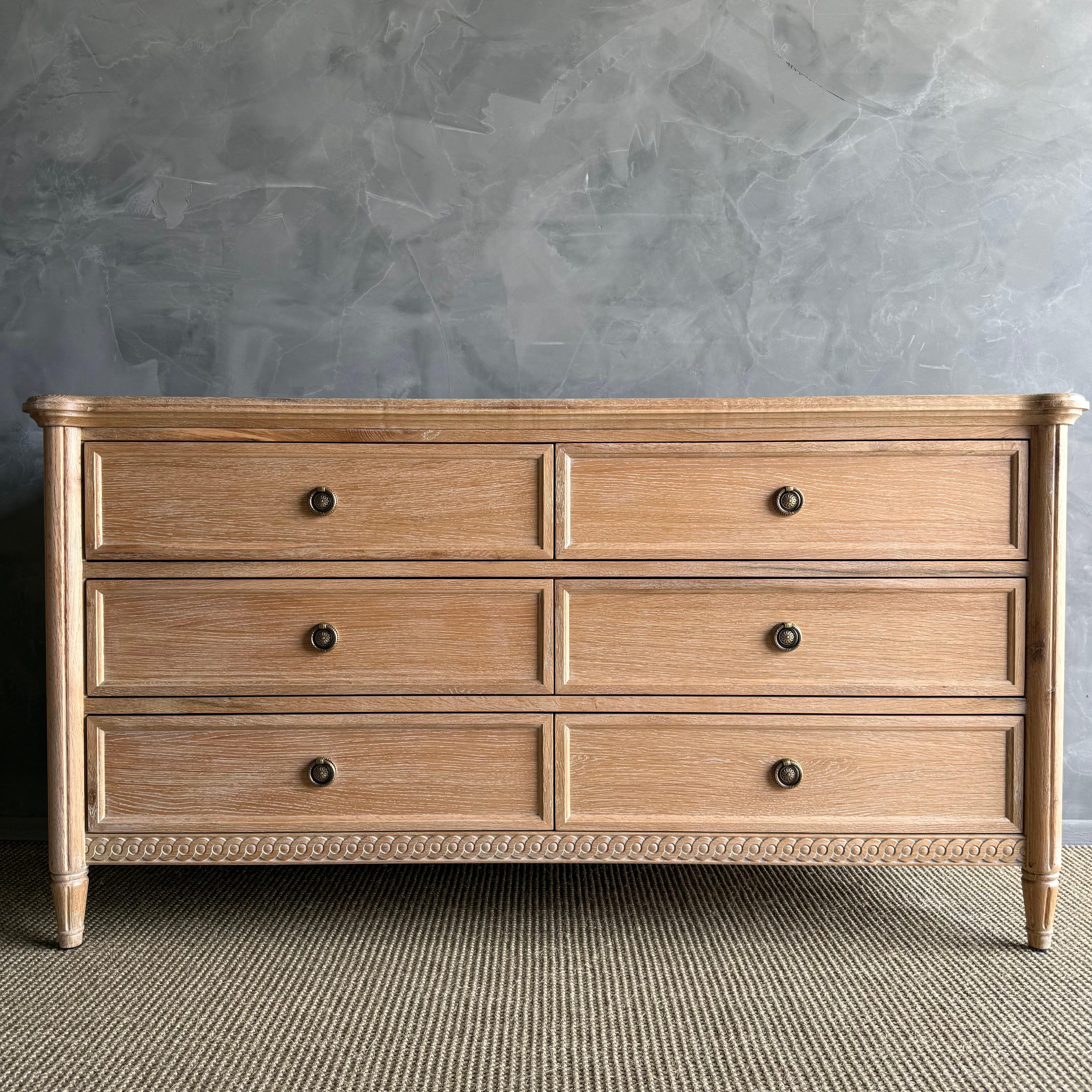 Comò a 6 cassetti in stile Luigi XVI con una splendida finitura in quercia bianca naturale. L'elegante design di questo comodino Luigi XVI è caratterizzato da dettagli intricati e da una lavorazione artigianale che emana lusso e raffinatezza. Con 6