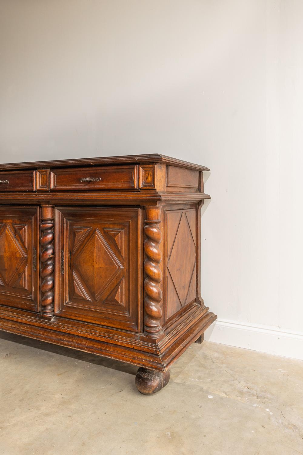 This Louis XIII walnut cabinet has a beautiful dark stain and so many unique carved details. There are two top drawers with original hardware and working locks and keys. The two lower cabinets have a beautiful carved diamond shape on the front. The