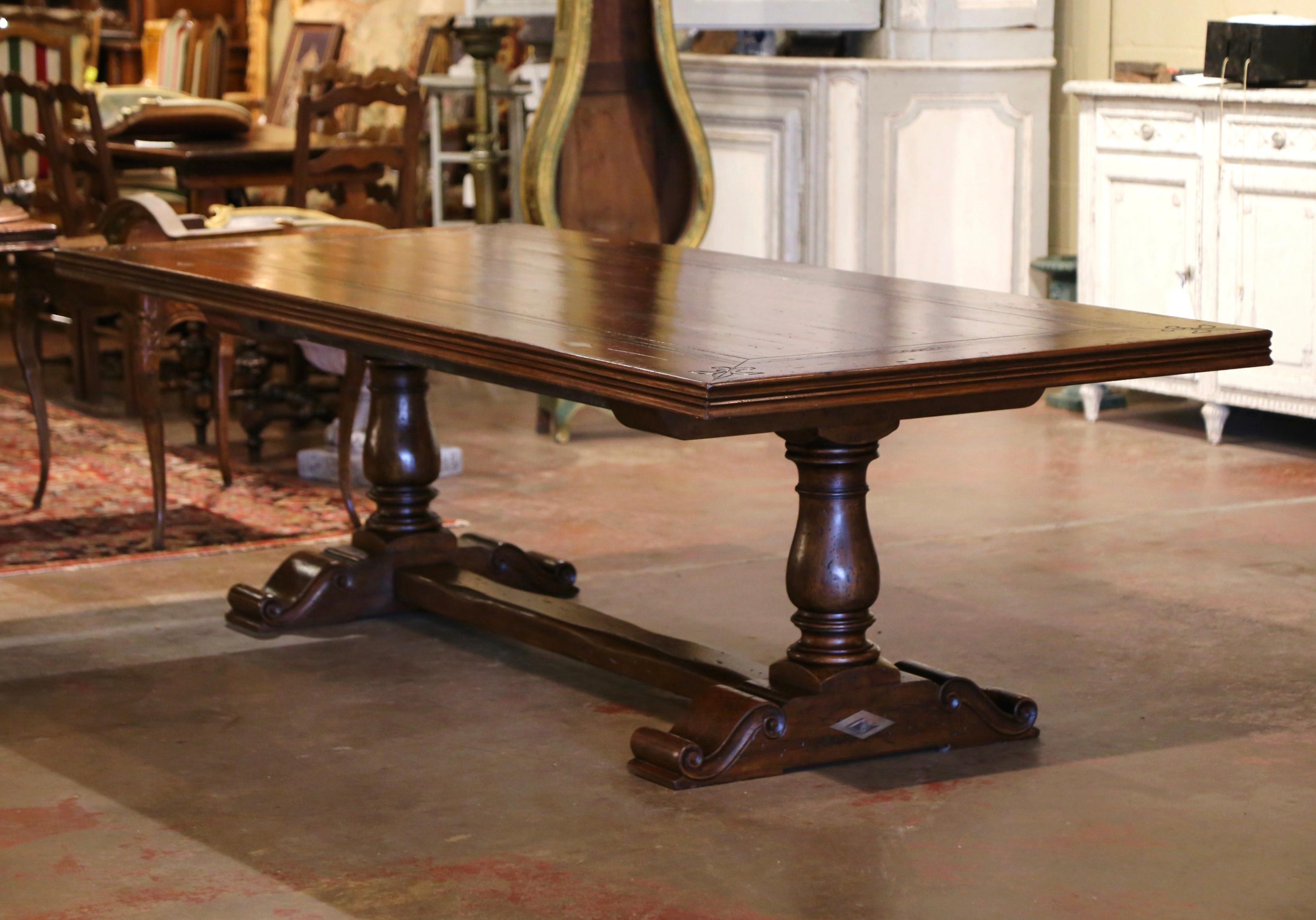  This large 9 feet long fruitwood dining table was crafted in southwest France, near the Spanish and French border. Built with antique walnut timber, the table stands on a trestle base, supported with hand carved baluster legs connected at the base