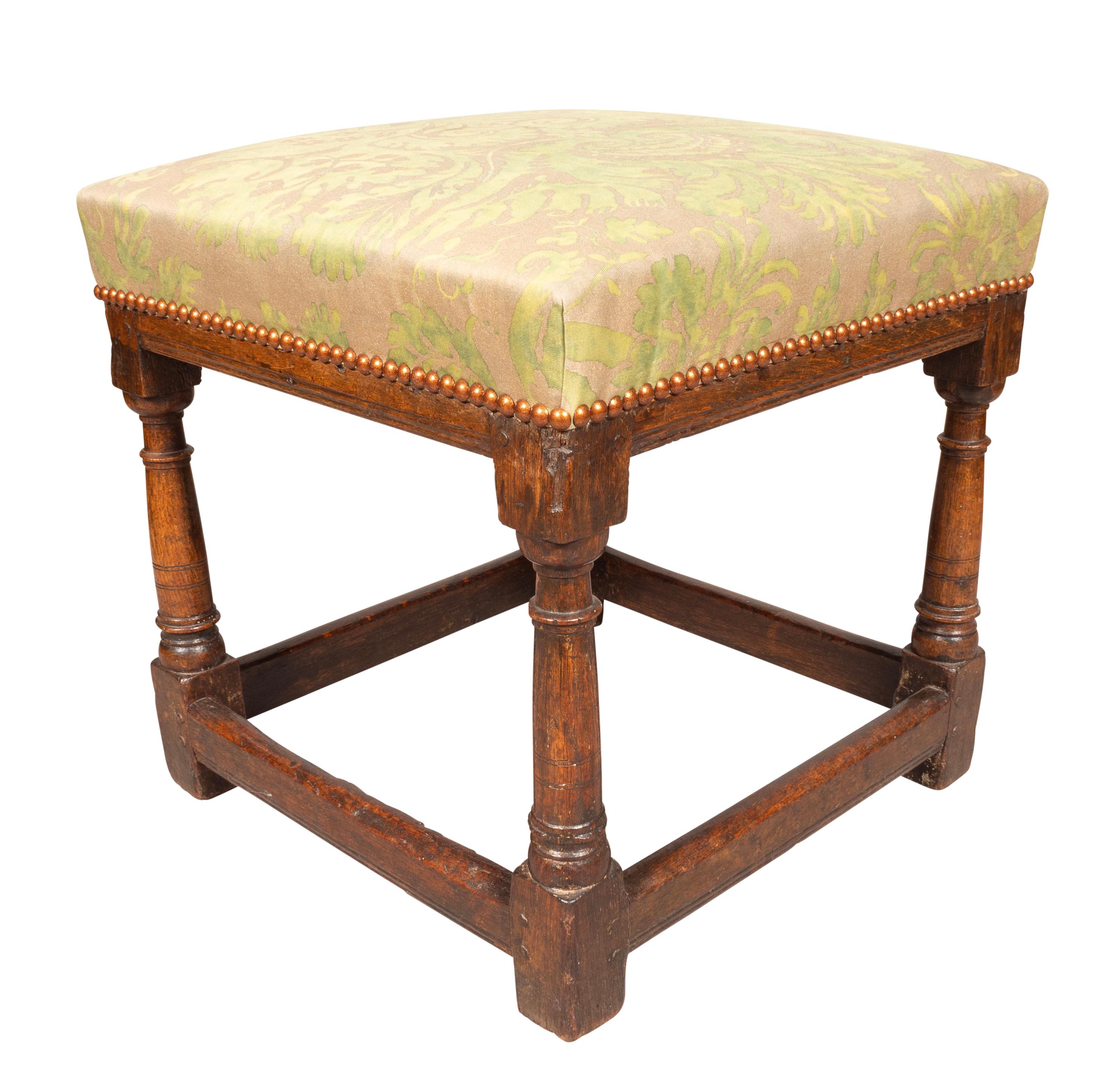 Square with Fortuny upholstered seat. Turned legs with box stretcher.