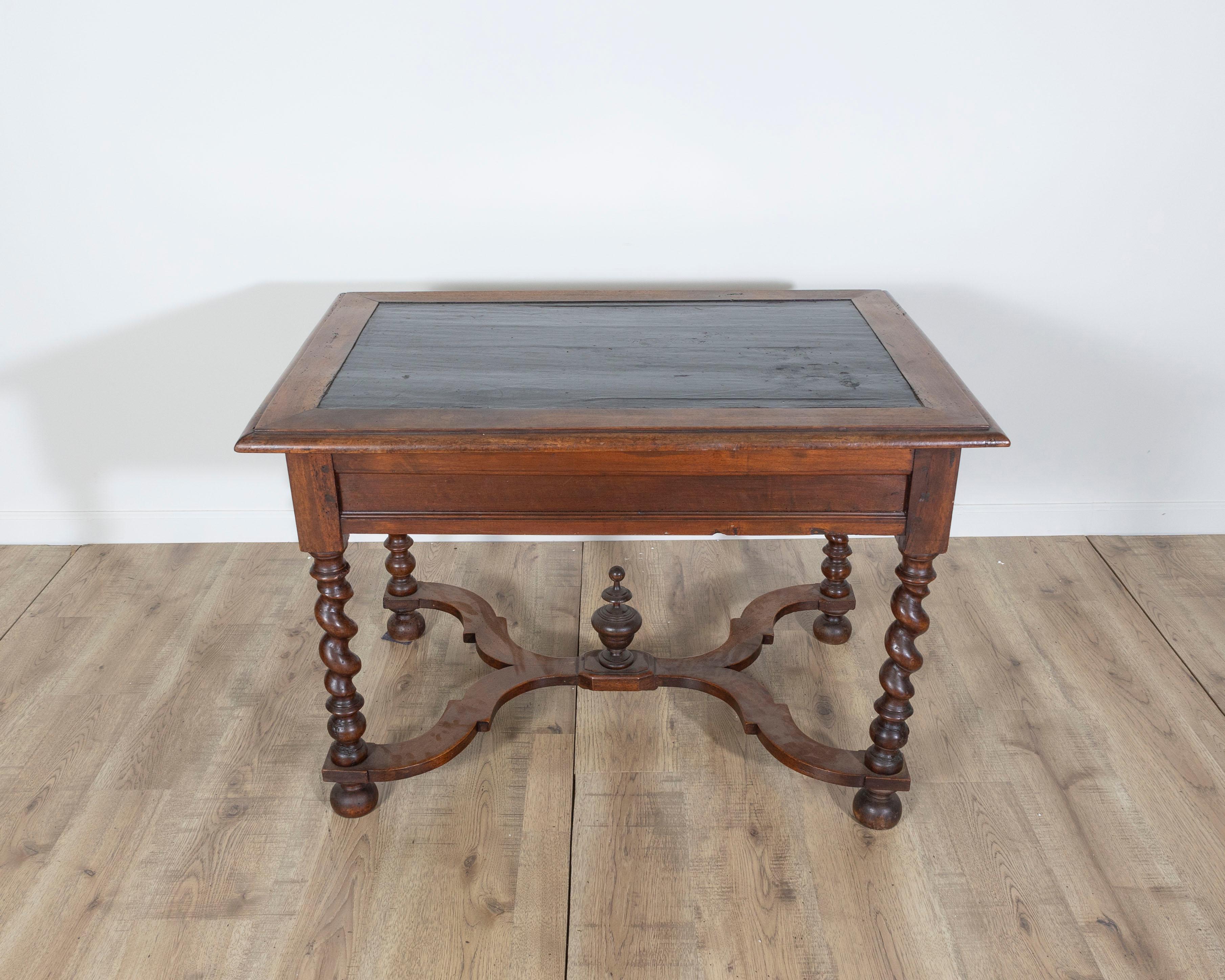 Laissez-vous emporter par la grandeur de l'histoire française avec cette table à écrire d'époque Louis XIII, fabriquée en noyer vers 1630. Cette pièce rare présente un plateau peint en noir encadré d'une bordure en noyer moulée, créant un riche