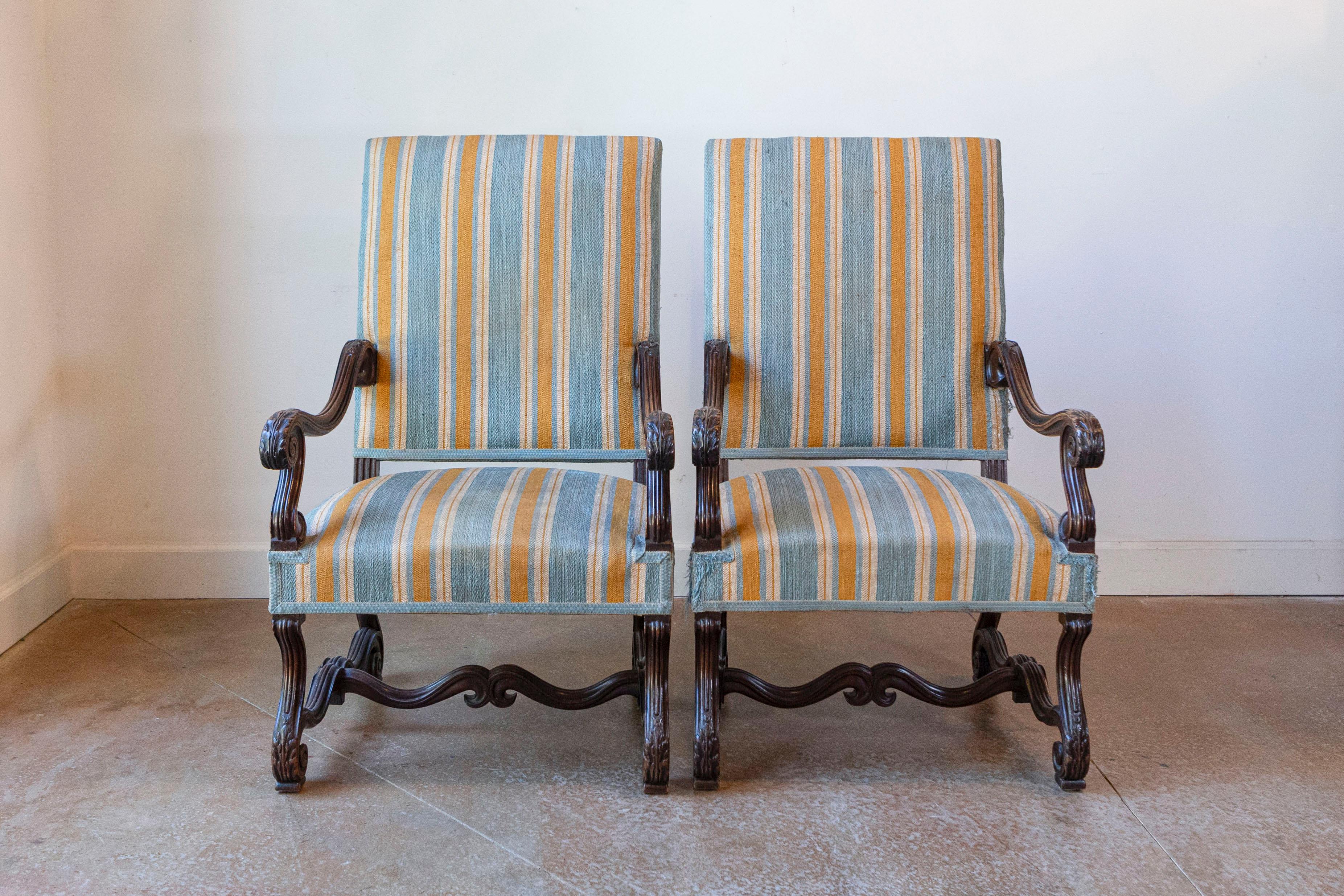 Coppia di poltrone francesi in stile Luigi XIII in noce intagliato del XIX secolo con ampi braccioli a scorrimento. Ammira l'eleganza senza tempo di questa coppia di poltrone francesi in stile Luigi XIII Os de Mouton, risalenti al XIX secolo.