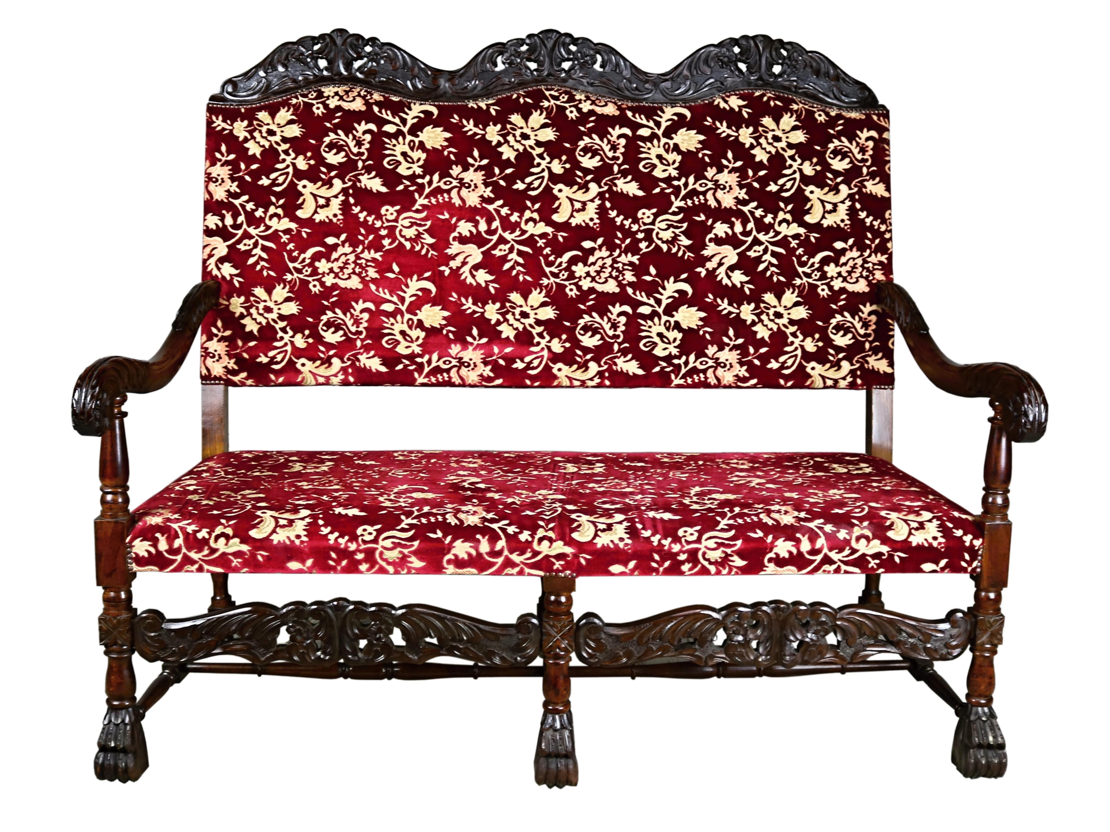 This elegant 19th century French Renaissance Revival seating set with new upholstery and hand-carved walnut legs, circa 1870s. It is a solid wooden construction it features a highly decorative character with a seat upholstered in red leather which