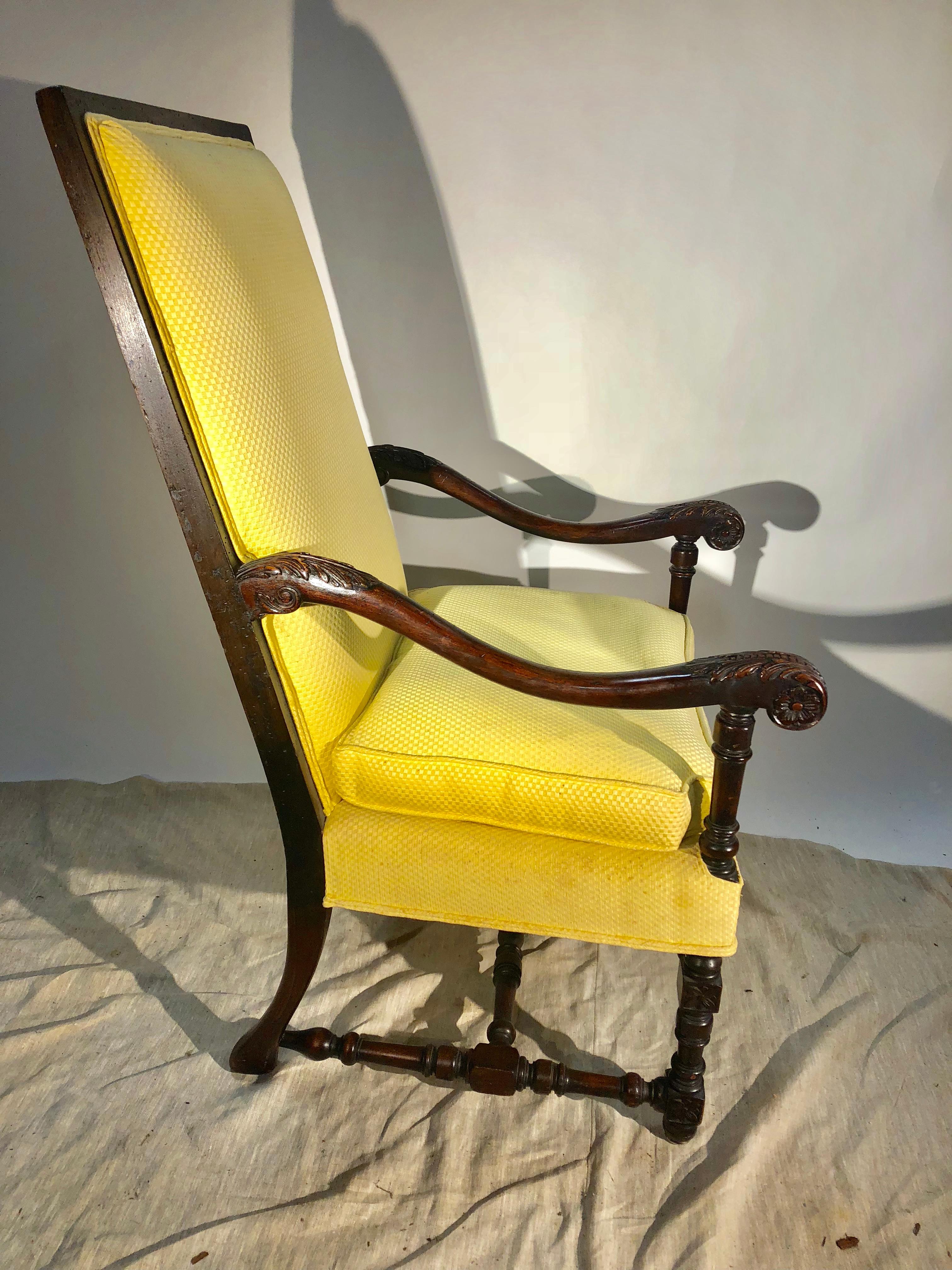 A Louis XIII style upholstered armchair in carved walnut, circa 1940, currently upholstered in yellow cotton fabric.