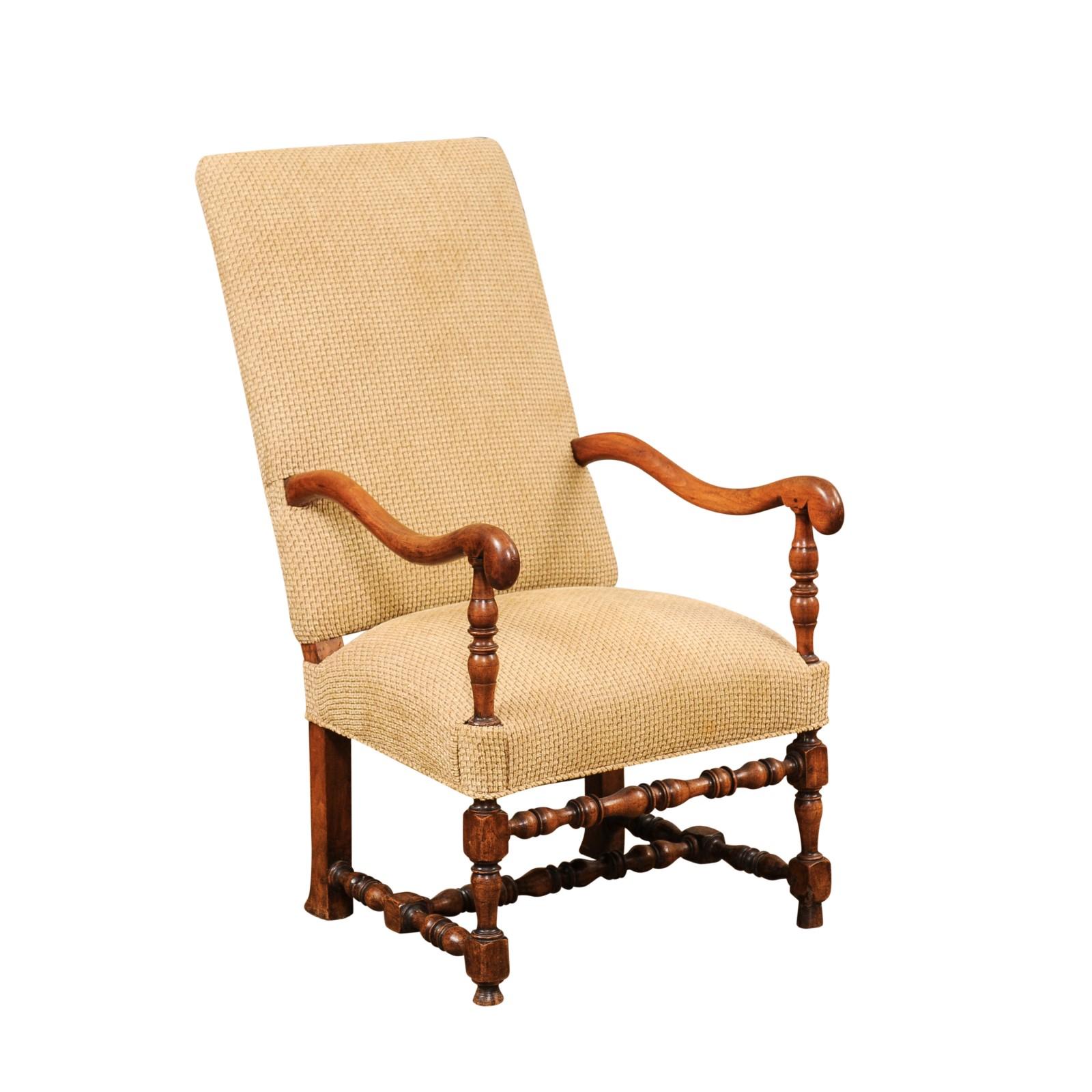 A single French Louis XIII style walnut armchair from the 19th century with large scrolling arms and turned base. This single French Louis XIII style walnut armchair, dating back to the 19th century, is a magnificent example of antique French