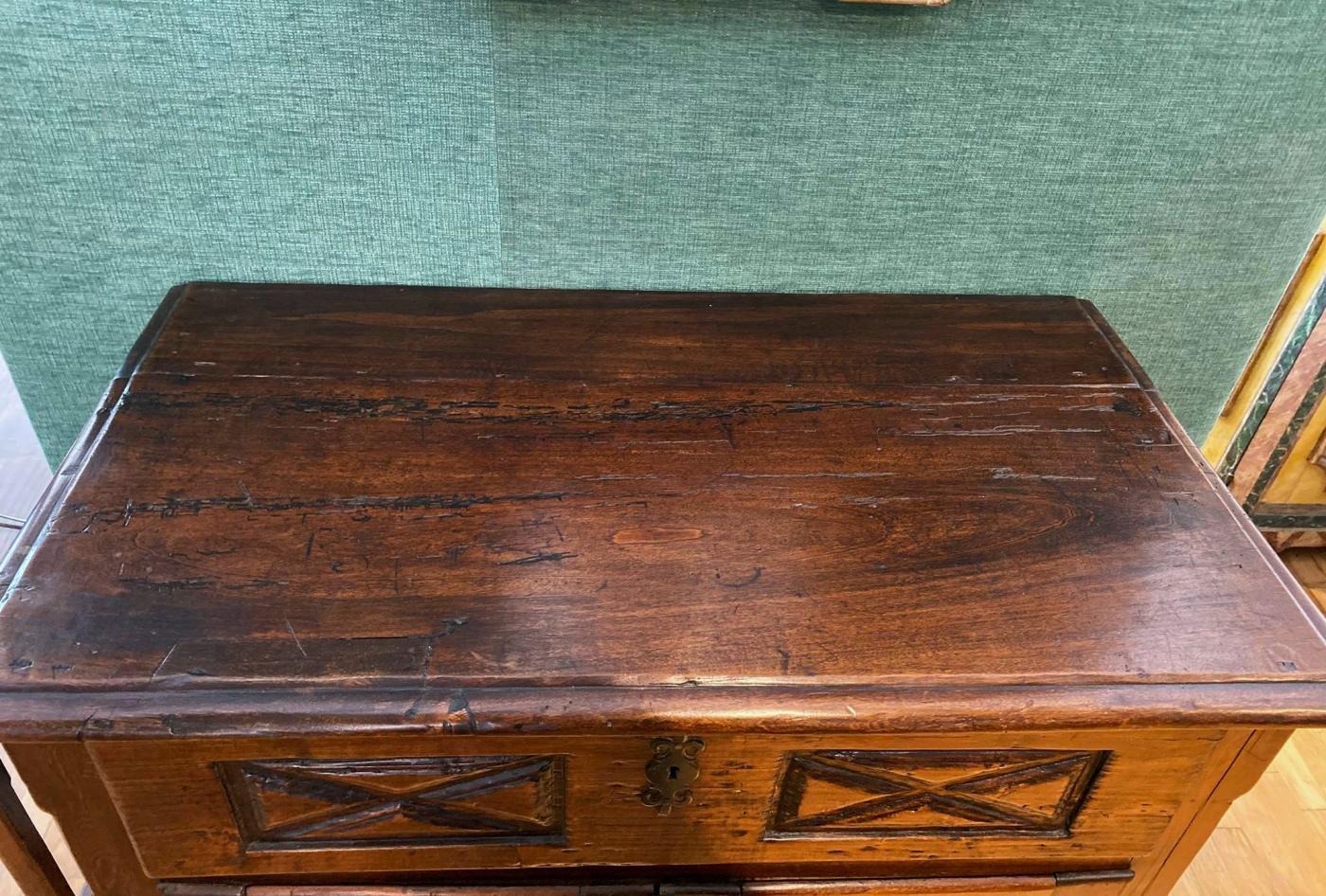 Rectangular top with molded edge over a long drawer, above a pair of paneled doors carved with diamond-shaped motifs, raised on plinth base.