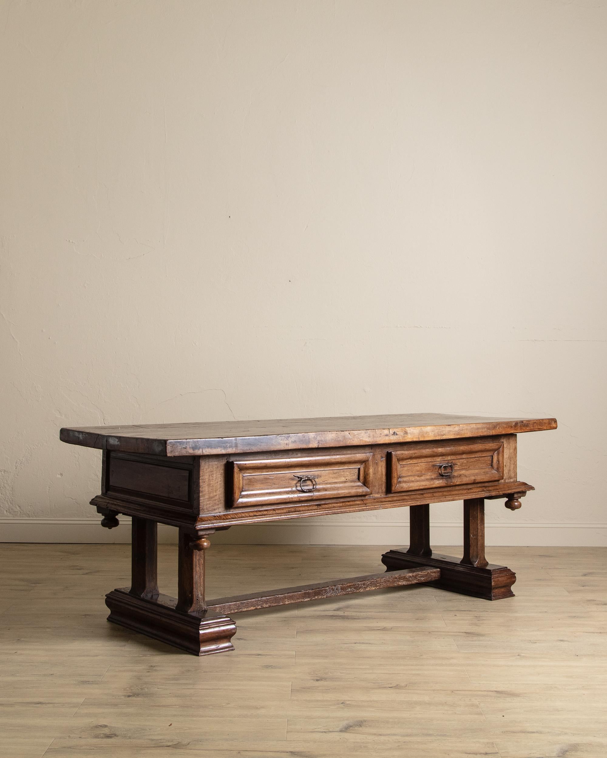 This eighteenth-century Louis XIII walnut desk embodies both elegance and practicality. Crafted with faux drawers on one side and functional drawers on the reverse, it balances decorative appeal with everyday utility. Its monumental yet transitional