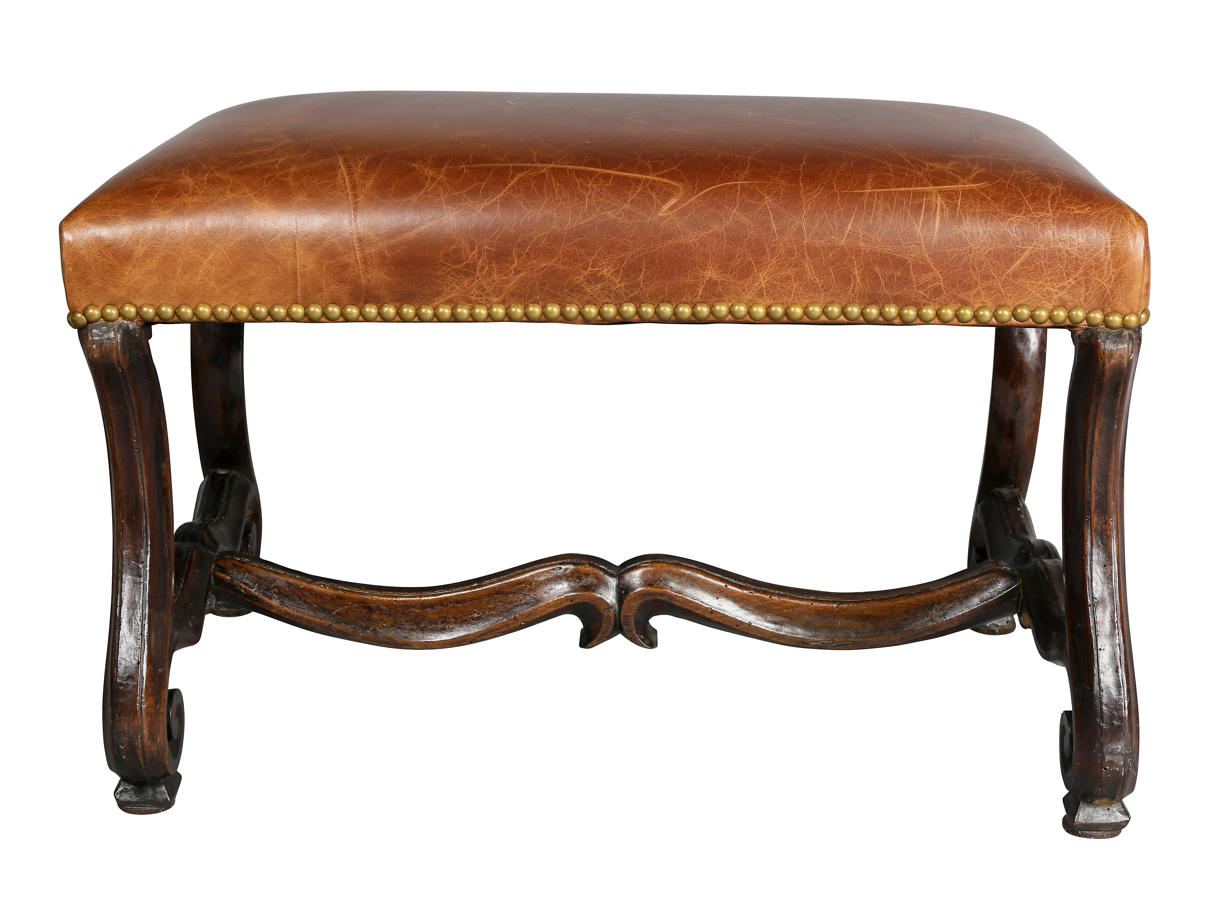 With rectangular brown leather seat with brass tacks, raised on Os De Mouton legs with stretcher.