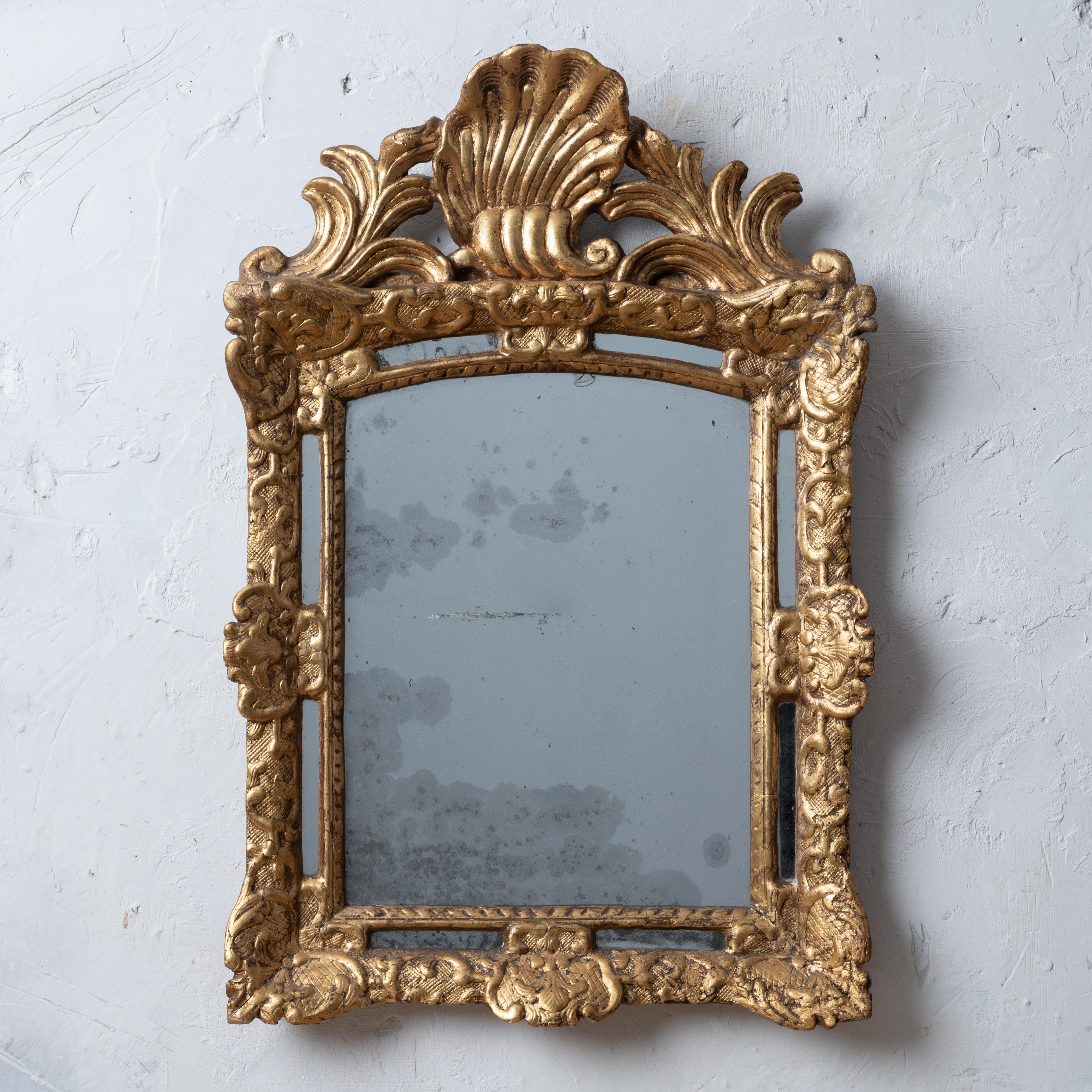 Miroir paraclose en bois doré de style Louis XIV, C.C.1700.
Bois sculpté et gesso. Motif bérainesque avec crête en forme de coquillage.

22 ½ pouces de large par 33 ¾ par 3 ½ pouces de profondeur

