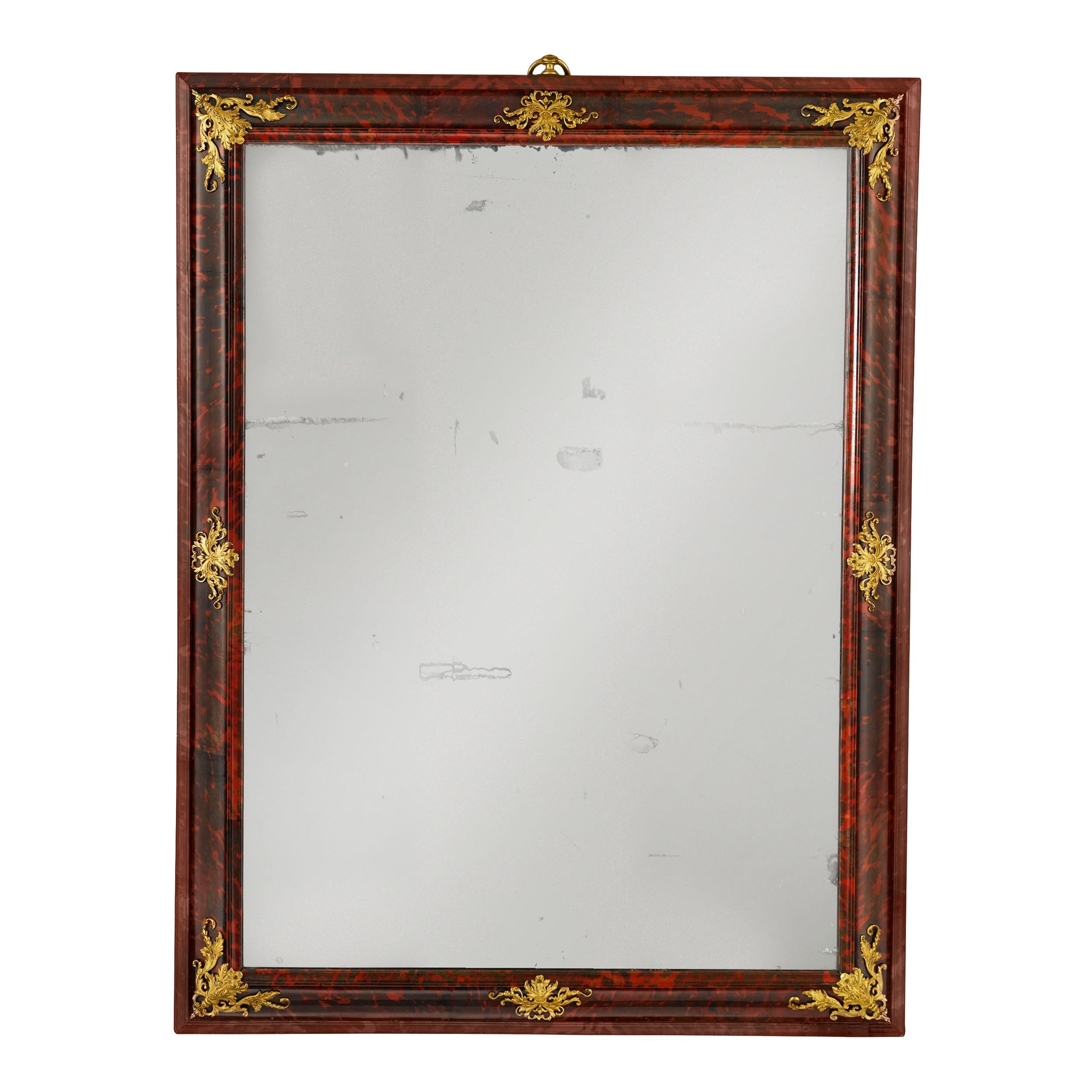 This magnificent and very rare Louis XIV period mirror boasts a frame of solid tortoiseshell veneer accented with intricate bronze ormolu mounts. This is an item of extraordinary luxury, as not only was mirror glass quite precious and in short