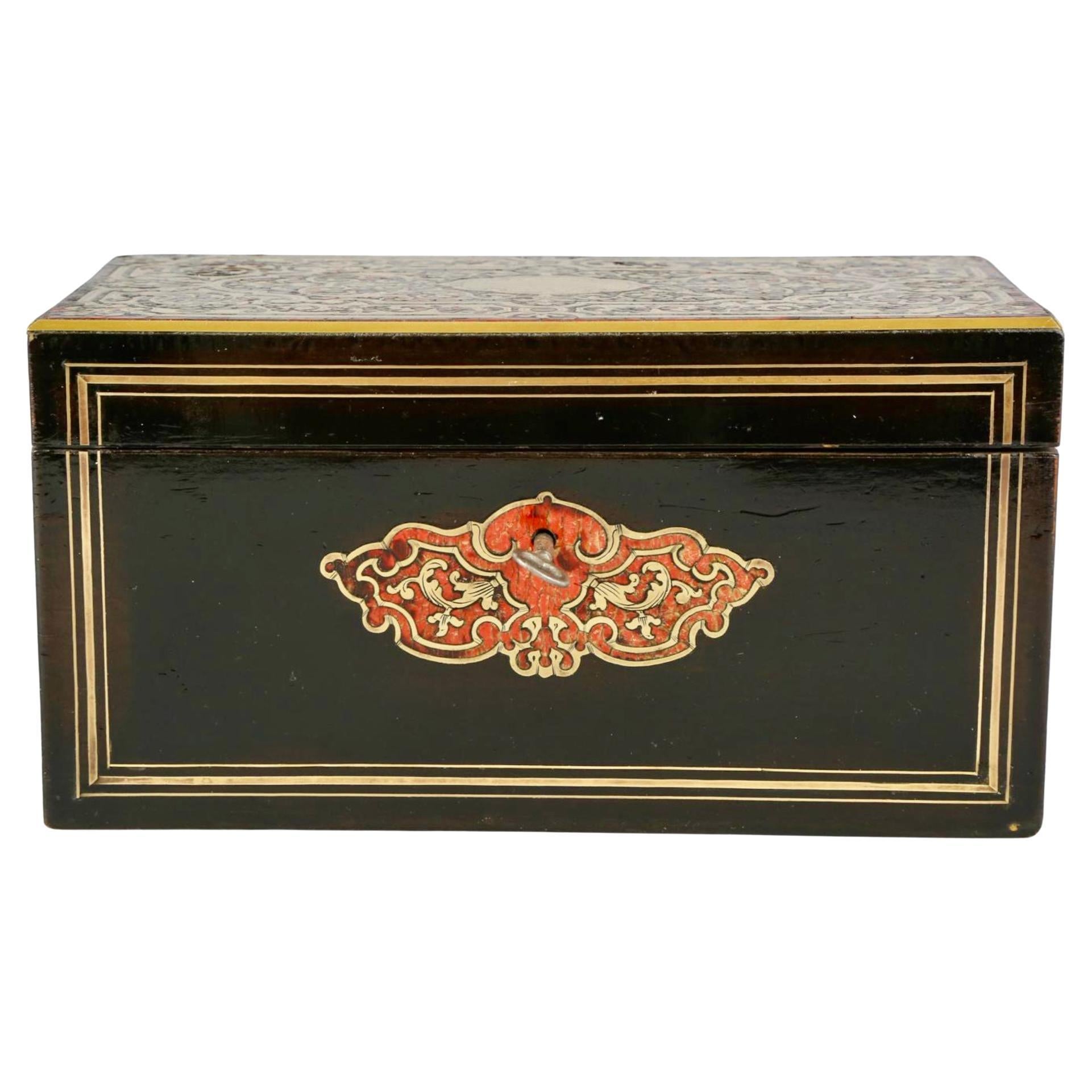 Porta tè in boulle in stile Luigi XIV del XIX secolo. La bellissima boulle ha un disegno intarsiato in rosso e oro su uno sfondo laccato nero. Dispone di un doppio cestino con coperchi in Wood. La chiave è inclusa nella confezione. 