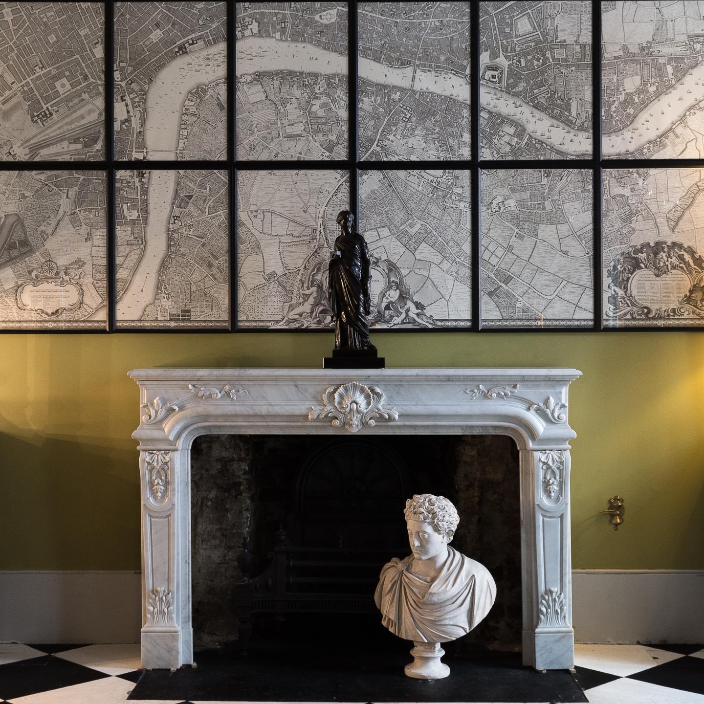 Louis XIV style Carrara marble fireplace, mid-19th century, the molded rectangular shelf above frieze centred by scallop shell and flanked either side with acanthine brackets, the voluted and paneled jambs with vents to either side, on plain