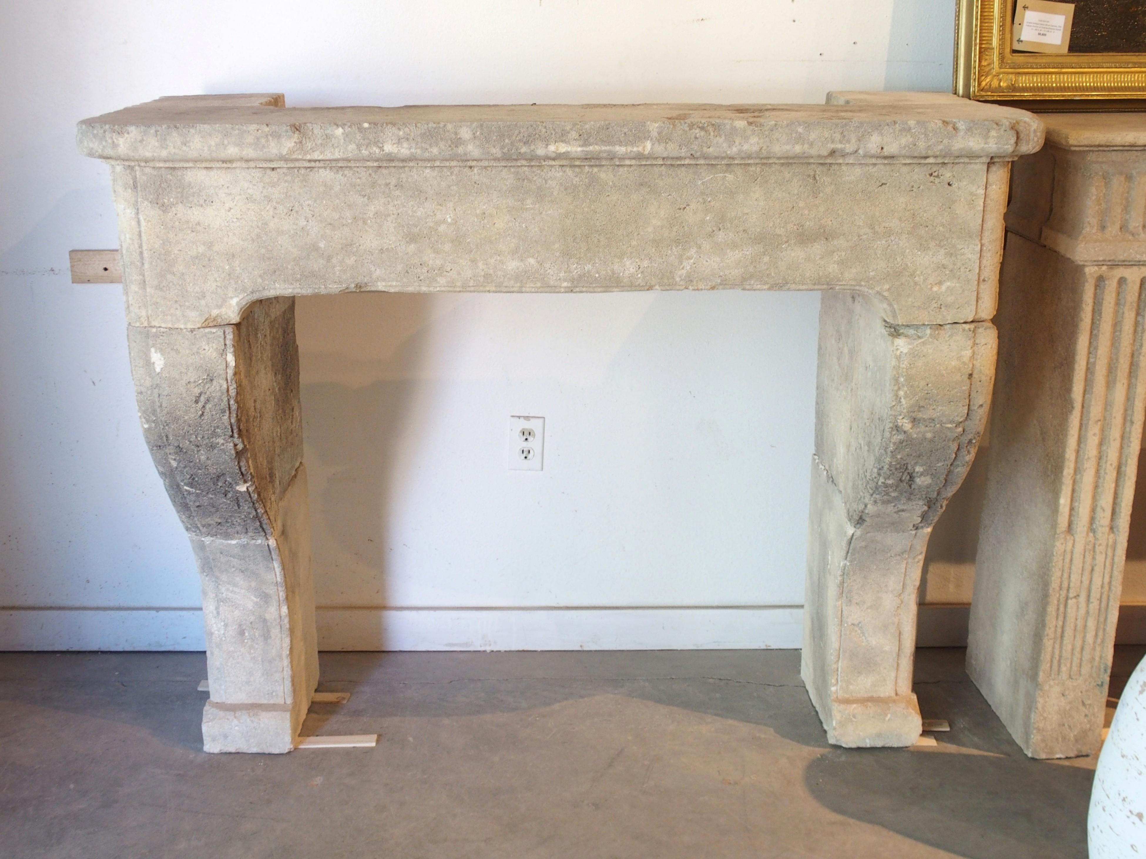 This fireplace mantel from the South of France has been hand-carved from seven pieces of Estaillade limestone in the style of Louis XIV. The stones have a gray hue, with cream and white accents, allowing the fireplace to be paired with just about