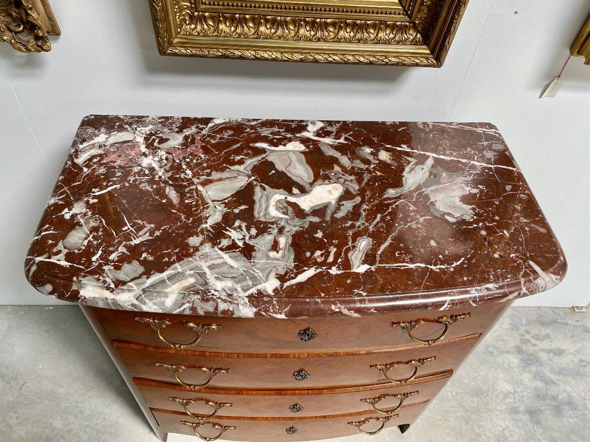A French Louis XIV style commode from circa 1950 with rosewood marquetry décor, four drawers, red griotte marble top and gilt bronze hardware. Crafted in the timeless French Louis XIV style, this circa 1950 commode radiates a classic elegance,