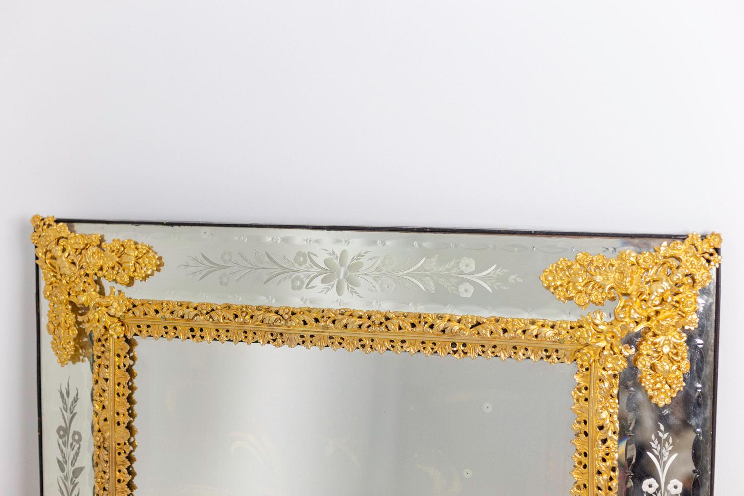 Rectangular shape Louis XIV style engraved mirror. Engraved edges with flowers and wheat ears friezes. Chiselled and gilt bronze ornamentation of an edge figuring palm leaves, flowers and acanthus leaves and spandrels decorated with putti surrounded